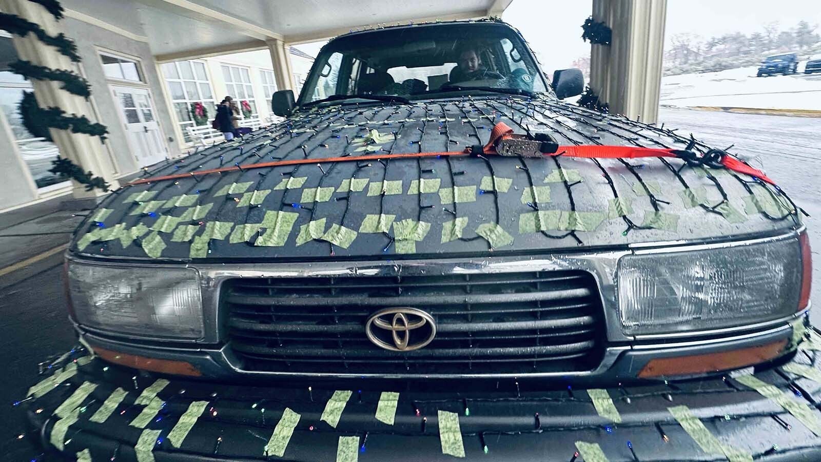 Timothy Erickson always wanted to transform his 1996 Toyota Landcruiser into a Christmas Cruiser. While driving to Mammoth Hot Springs, a wind gust busted his hood latch, so he had to strap down the hood on his yuletide 4x4.