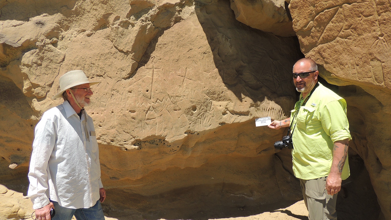 Craig Bromley and William Elder examining the petroglyphs at the White Mountain Petroglyph Site near Rock Springs. Elder believes this was a birthing and fertility site for indigenous people, but Bromley said he needs more evidence before he and other archeologists are convinced.