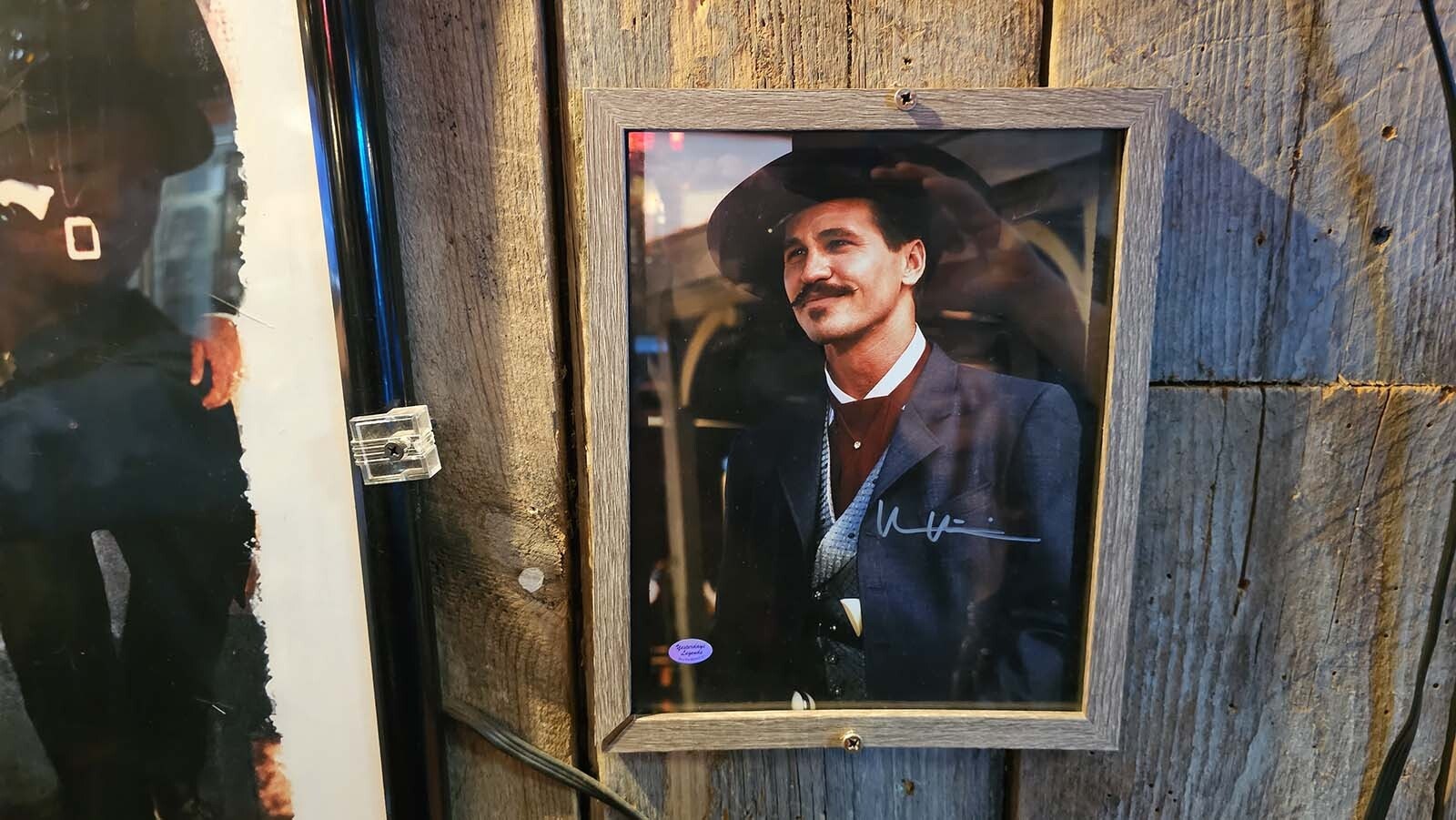 A signed photograph of Val Kilmer right next to a movie poster of Tombstone  at the White Wolf Saloon in Douglas.