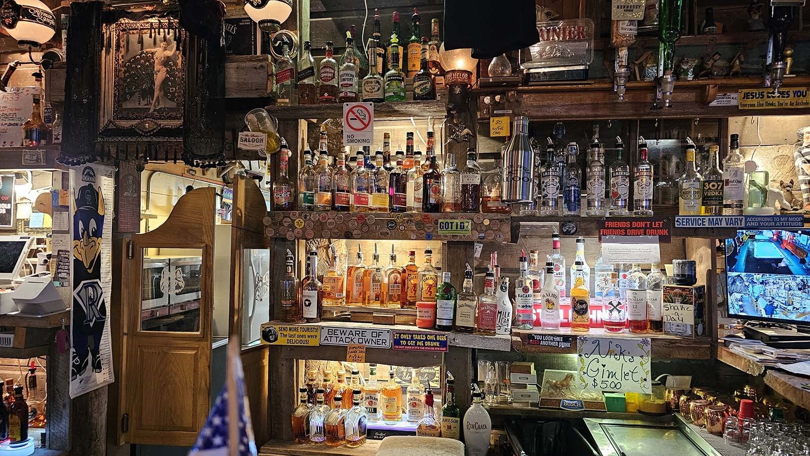 Wood from the original saloon is displayed behind the bottles of liquor  at the White Wolf Saloon in Douglas.