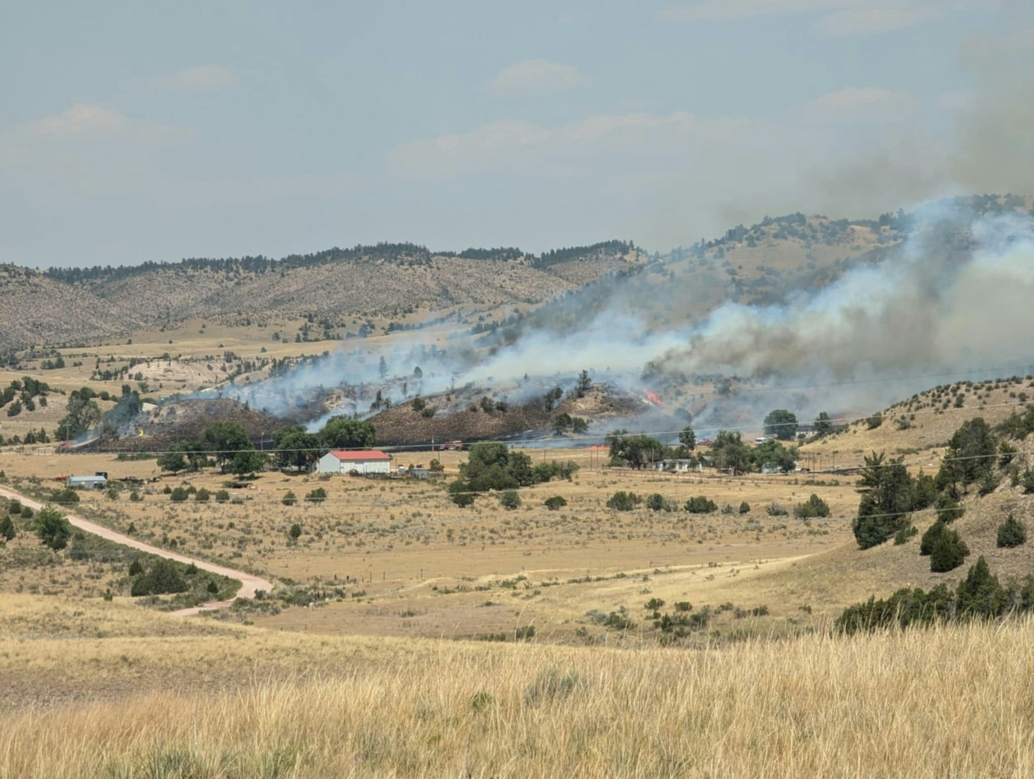 Looking northeast from just north of Guernsey, Wyoming, on Tuesday afternoon shows areas of wildfire threatinging homes and outbuildings.