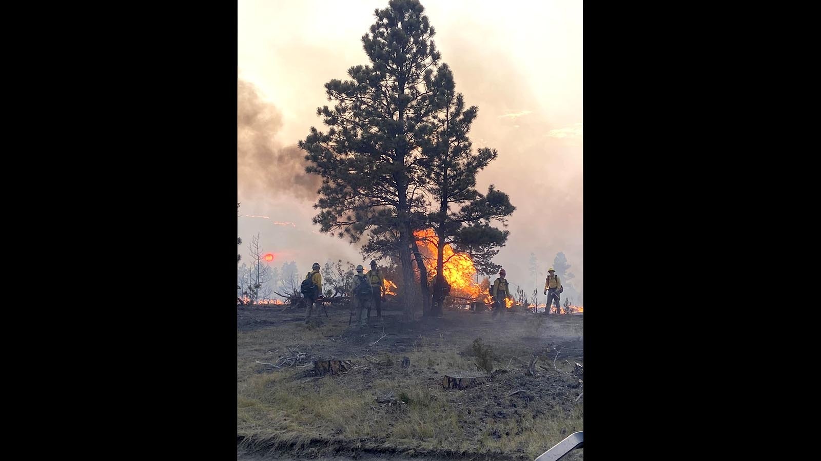 Firefighters work to contain a wildfire near Upton, Wyoming.
