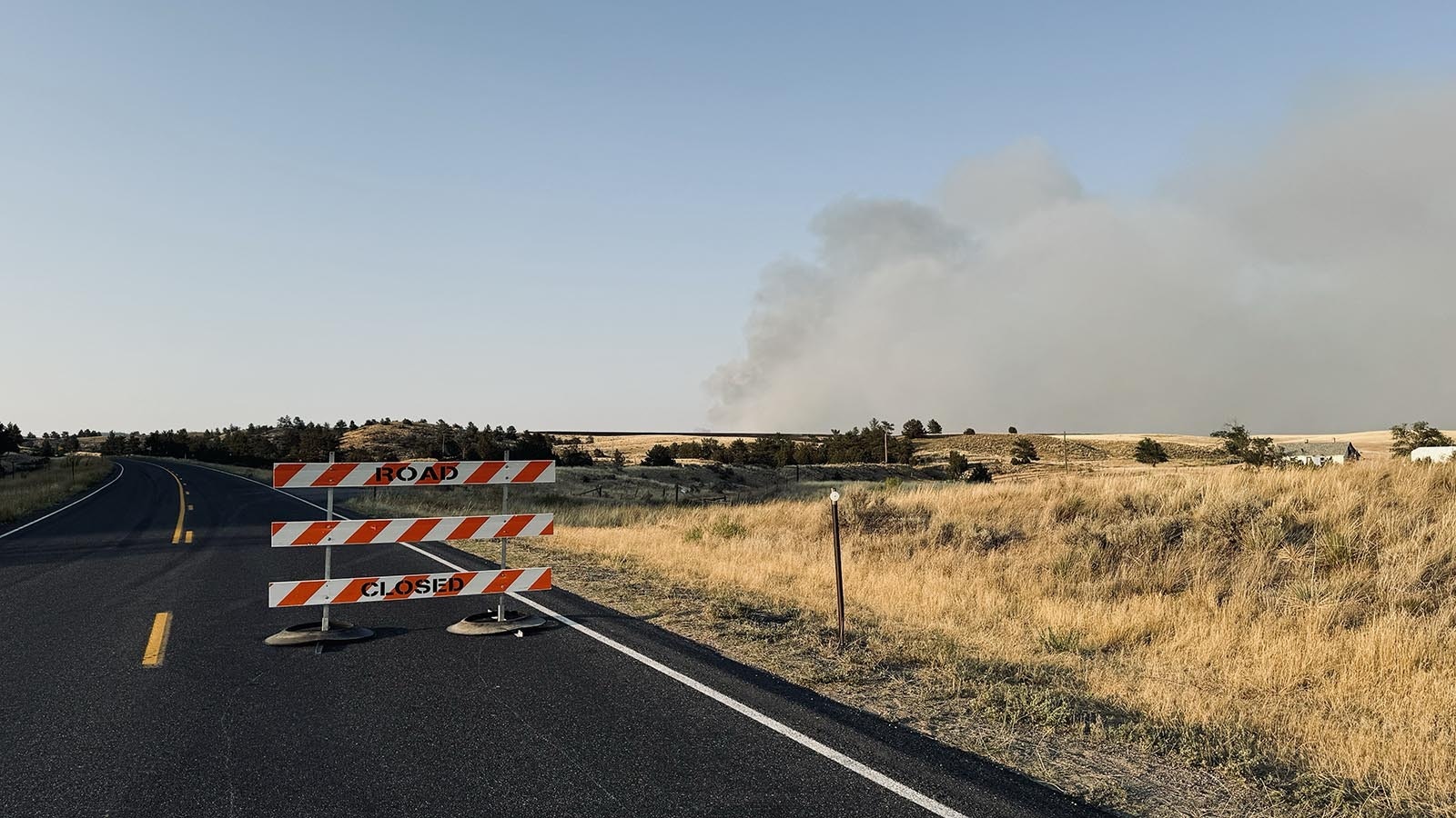 The main highway into Guernsey, Wyoming, was closed Wednesday because of an out-of-control wildfire. Although the fire remains uncontained, the road has been reopened.