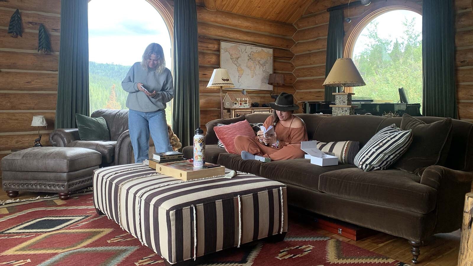 Emily Warren seated on the couch of her cabin in Wilson, Wyoming, while writing "Dont Start Now," which became a smash platinum-selling song for Dua Lipa. She's working with songwriting partner Caroline Ailin.