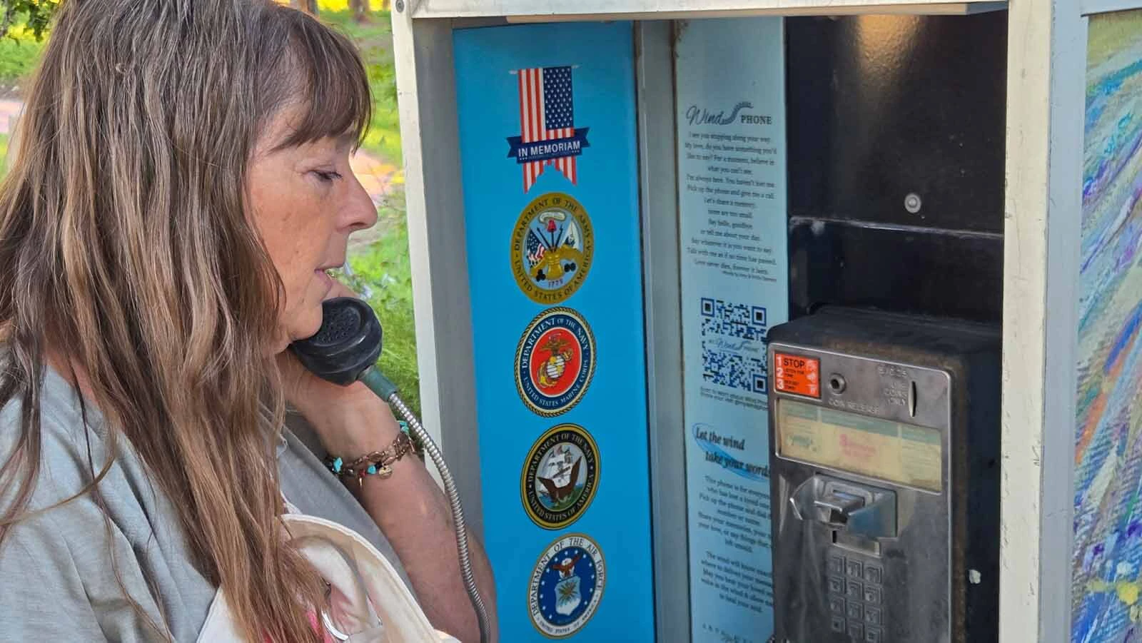Terry Anne Heglund holds the receiver of Douglas’ new Wind Phone, a disconnected payphone where people can speak aloud to loved ones they’ve lost.