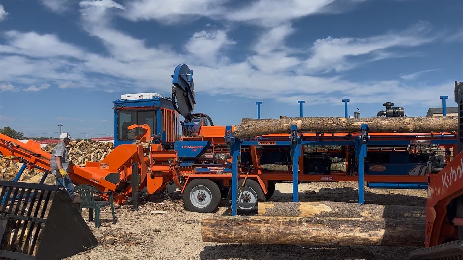 A saw blade cuts the logs into the proper length for firewood.