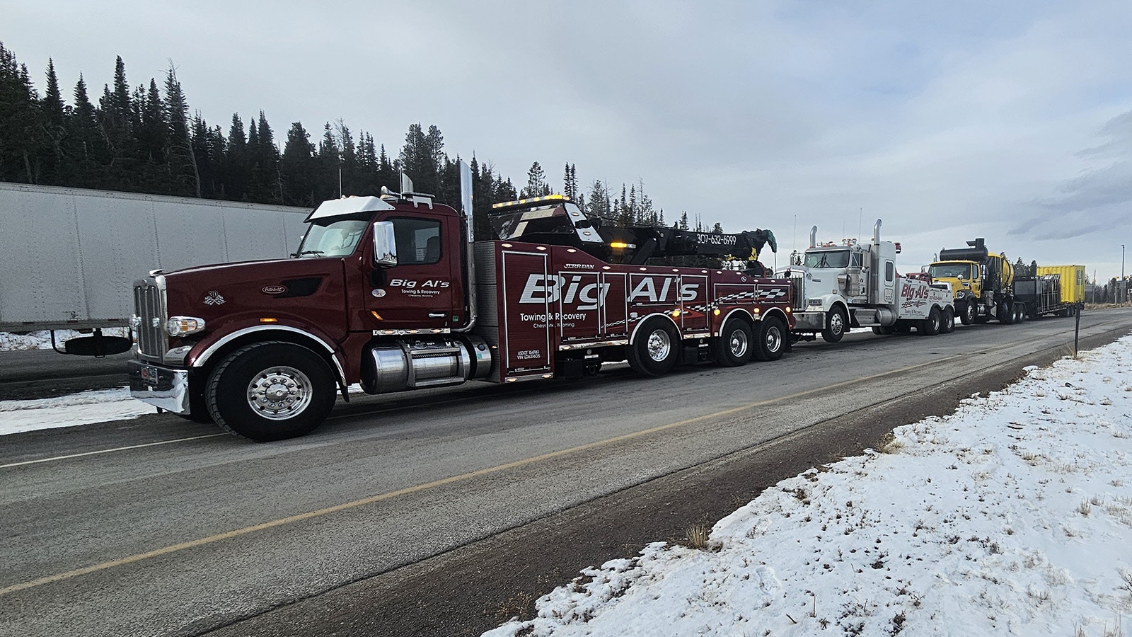 This is a tow truck pulling a tow truck pulling a truck pulling a trailer.