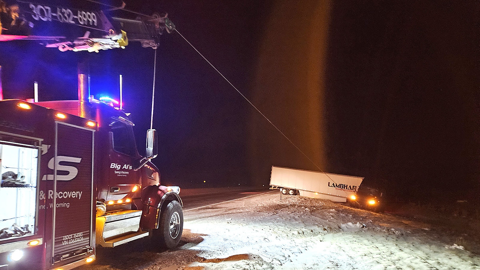 Winching out a semitrailer on a winter night.