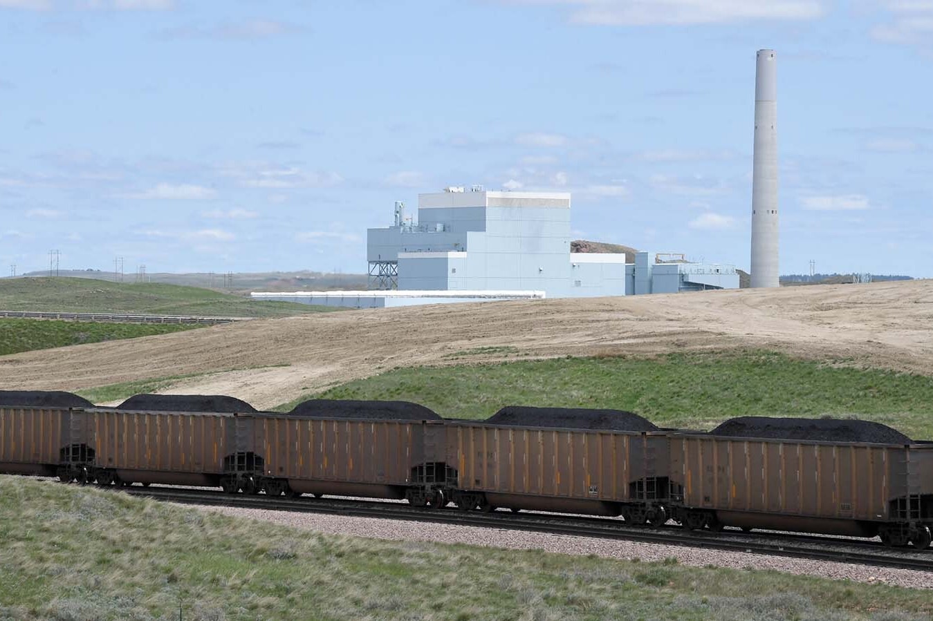 A full coal train rolls through Wyoming's Powder River Basin about 10 miles north of Gillette. The Dry Fork Station coal-fired power plant is in the background.