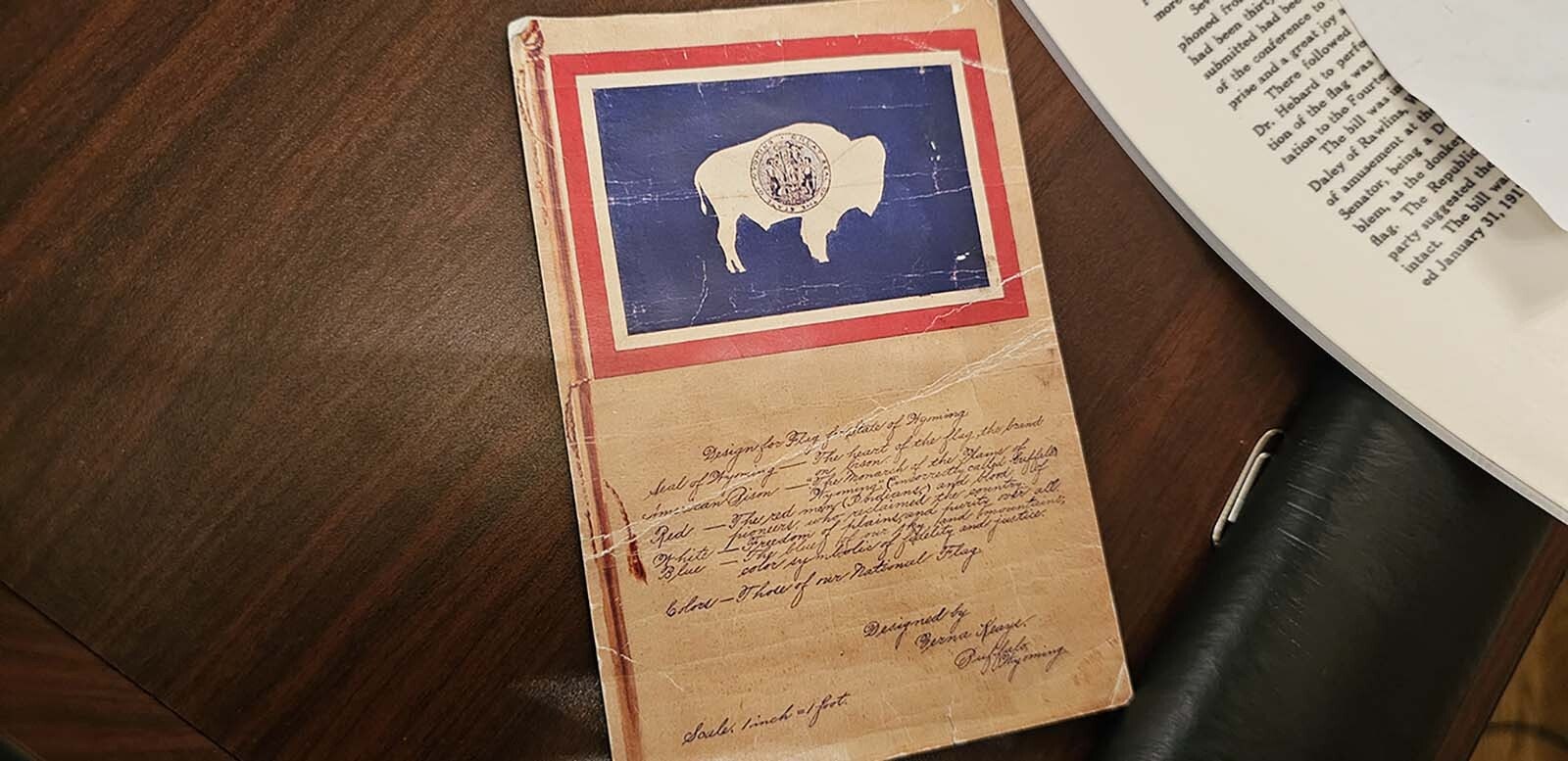 A copy of Verna Keays Keyes' original design, with the bison facing away from the staff, roaming free in a field of blue.