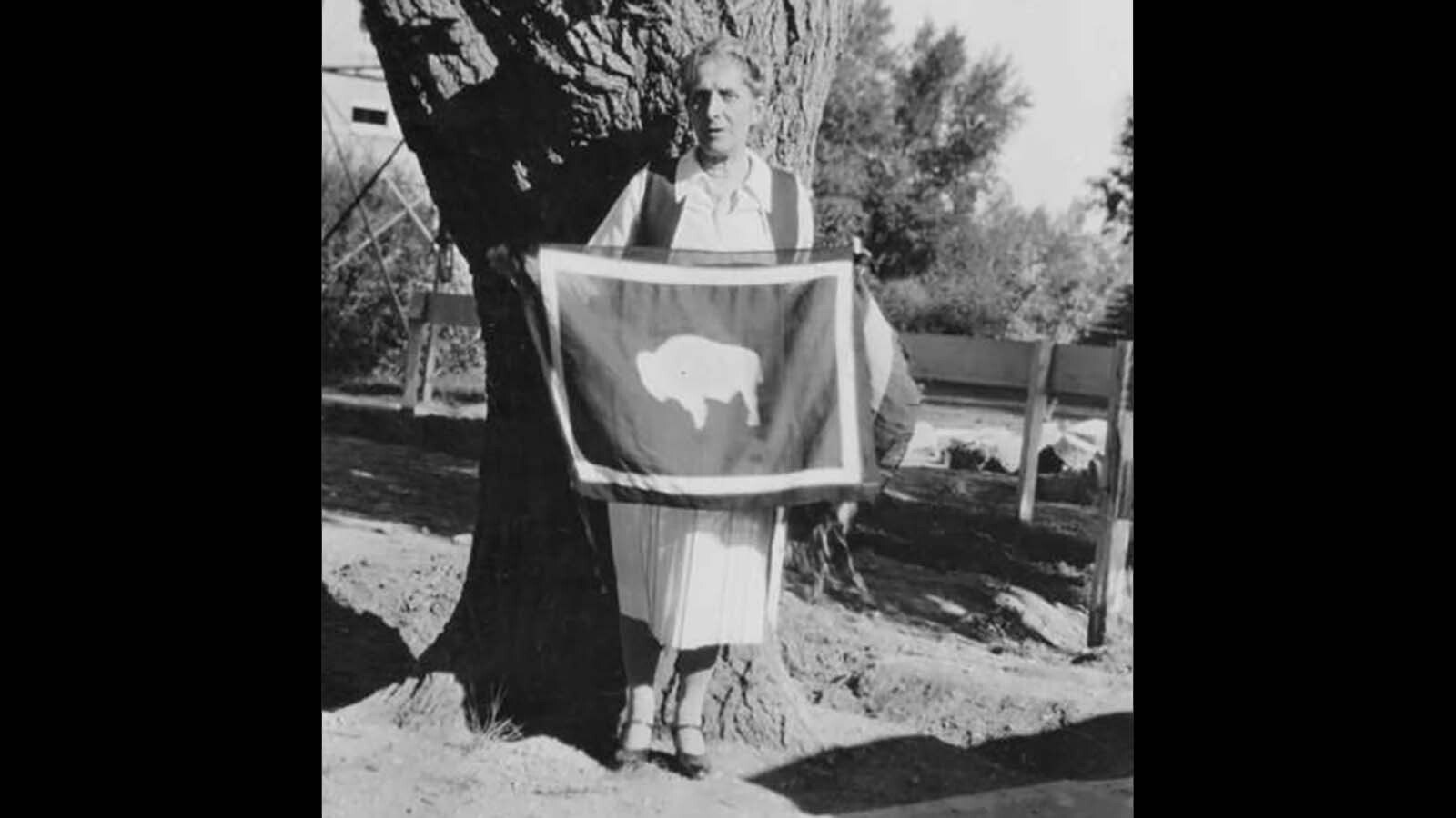 Grace Raymond holds a Wyoming state flag in 1930. She's holding the flag with the bison facing left, implying it would be facing the flagpole, which she insisted was the correct orientation.