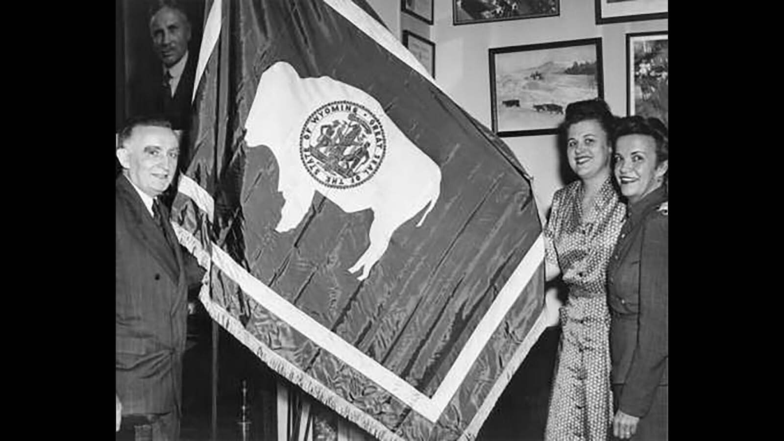 By the 1940s, it had become standard for the bison on the Wyoming state flag to face the pole. Above, U.S. Sen. Joseph O'Mahoney, left, and two staffers with the flag. Above the senator's head is a portrait of former Gov. John Kendrick, who signed the flag design into state law in 1917.