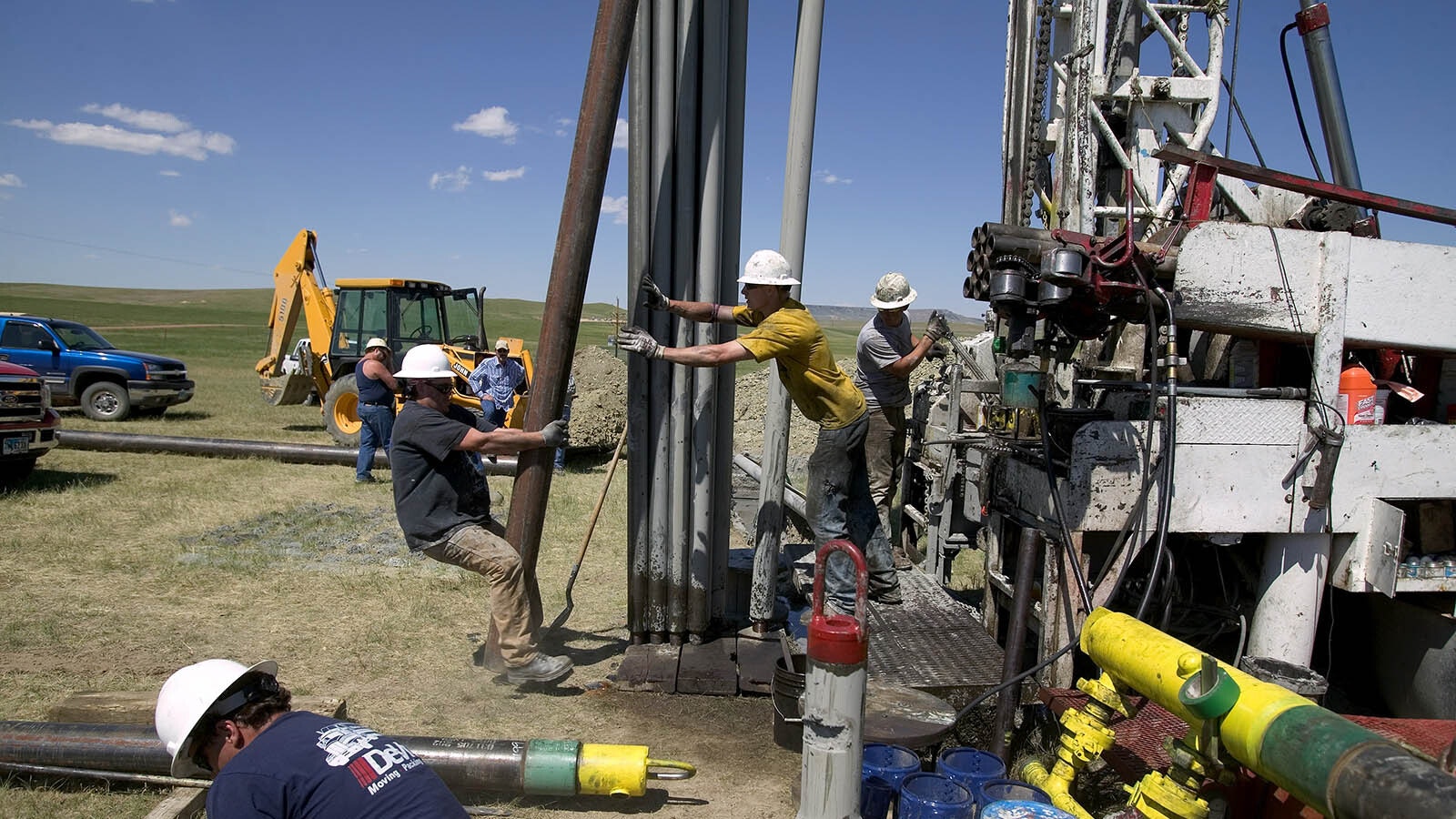 Drilling hands prepare to tighten 10-inch metal pipe casing that will be connected and fitted into a drilled well in Wyoming's northeastern Powder River Basin south of Gillette in this file photo.