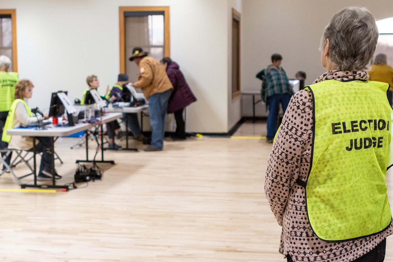 An election judge observes as voters sign in at a polling place in Cheyenne in November 2022.
