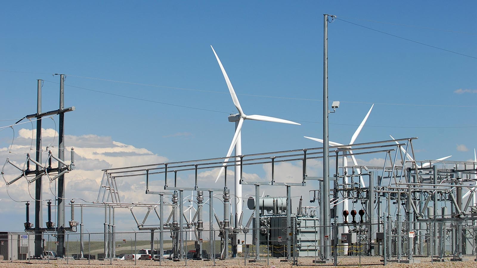 A power substation with wind turbines in the background in Wyoming.