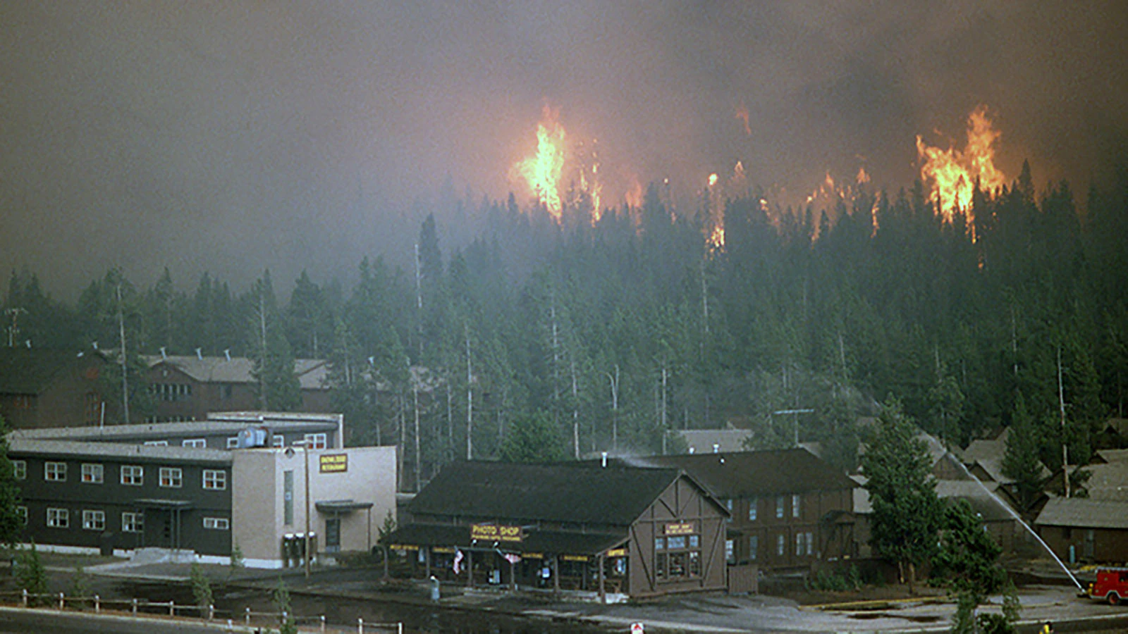 Firefighting crews pour water on the Old Faithful Snowlodge in Yellowstone National Park in summer 1988.