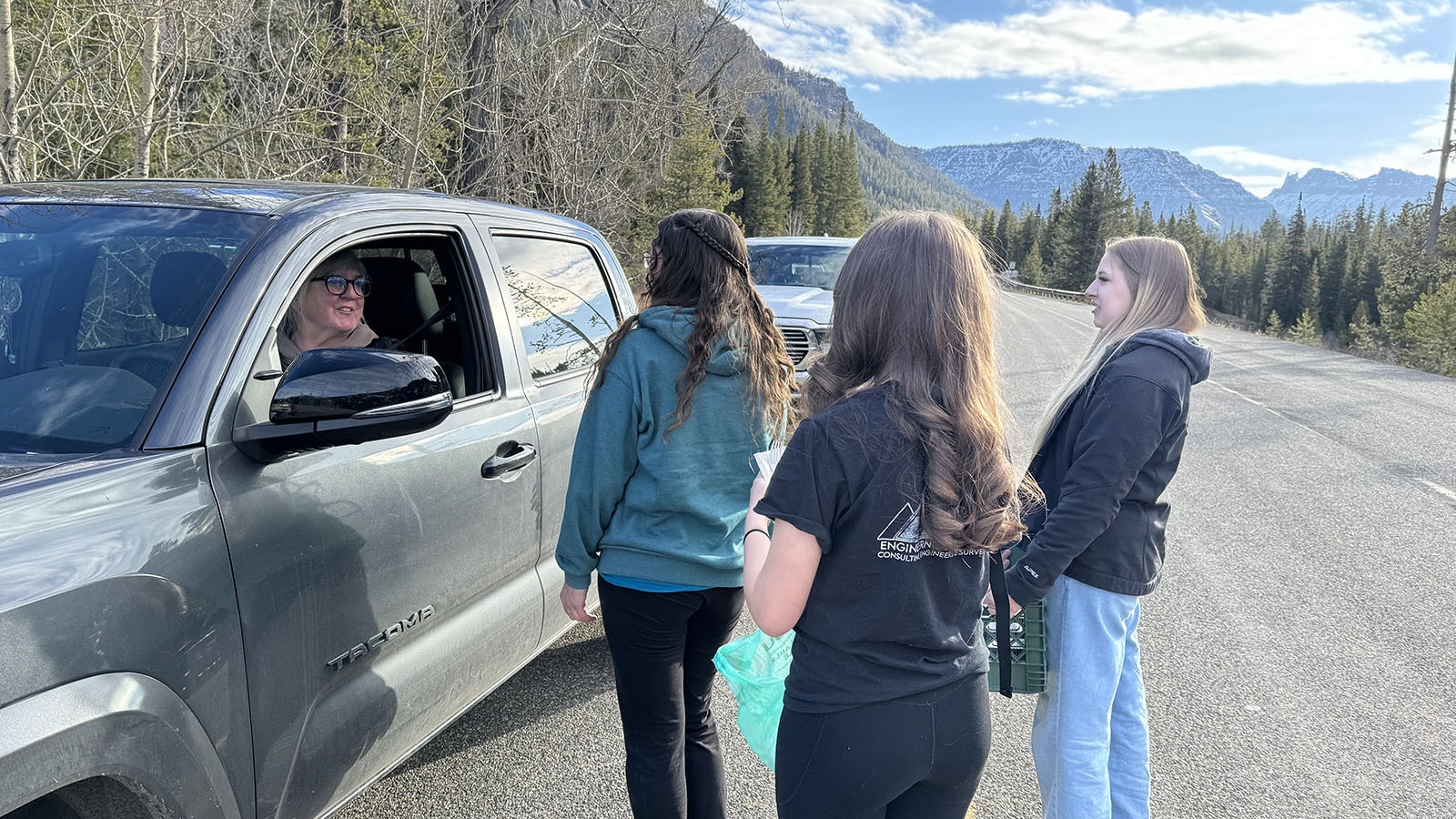 Stacy, Hailey, and Grace giving homemade carrot cake to the other people in line for the opening of the East Entrance of Yellowstone on Friday morning.