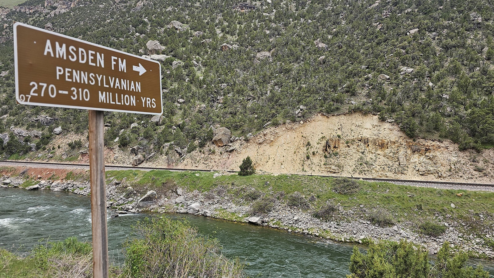 Signs along the Wind River Canyon point out the layers of time that each rocky deposit represents.