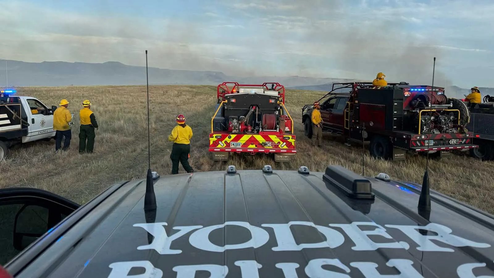 Flames creep across the landscape behind Yoder Volunteer Fire Department trucks. The tiny Goshen County department has become an outsized force in Wyoming's wildfire response efforts.
