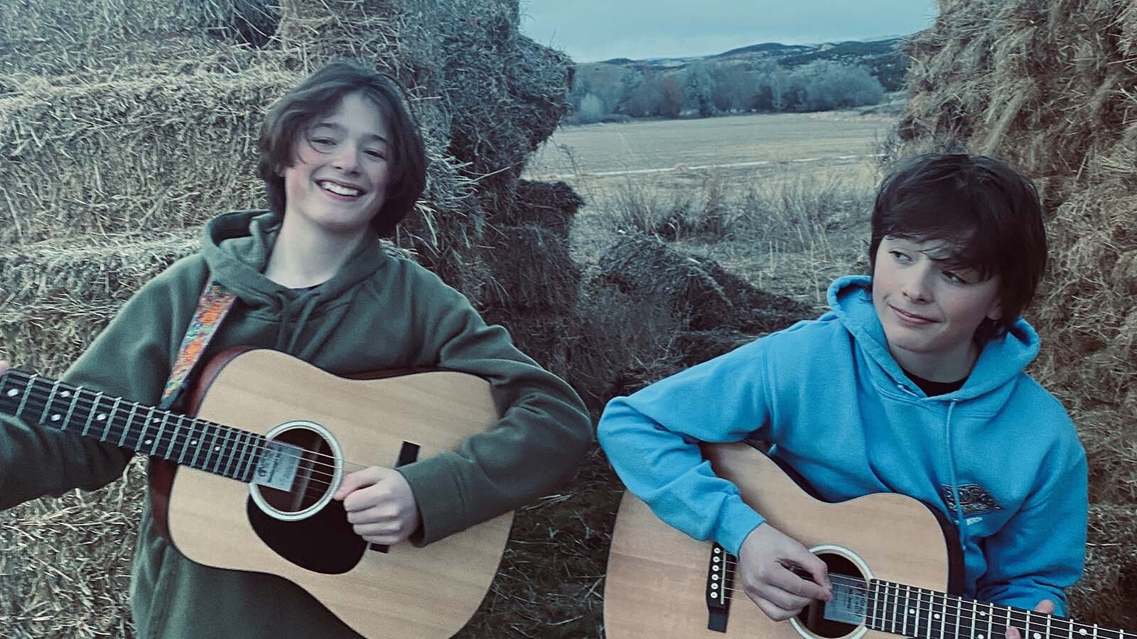 Liam, right, and Layne Jordan, both 13, playing outside at a haystack near their home in the Medicine Lodge Archaeological Site in the Bighorn Basin.