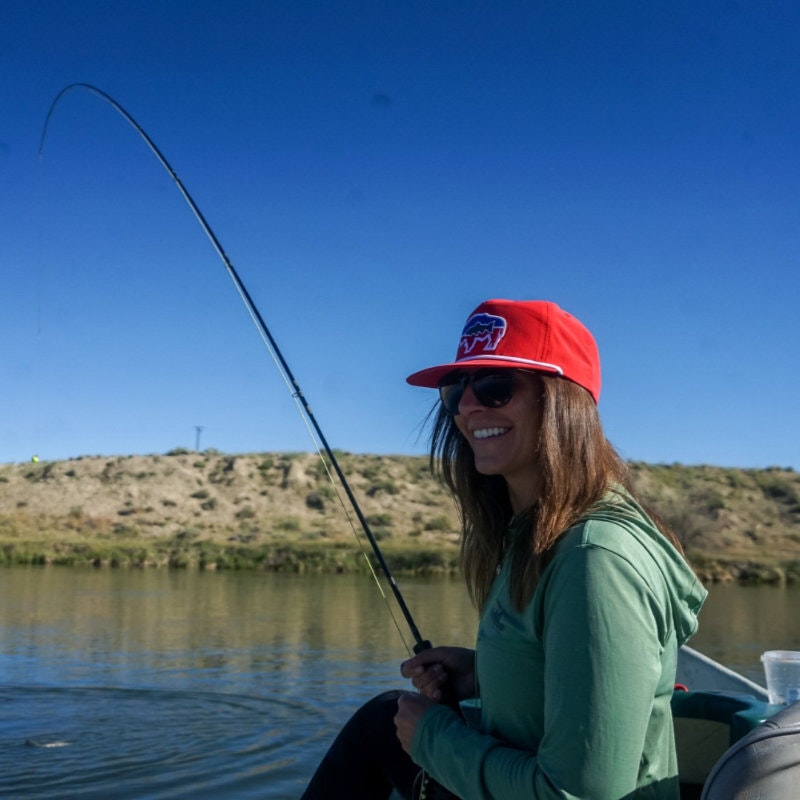 Image of Cowboy State Daily's advertising operations coordinator, Abby Roich fishing on a boat in a lake.