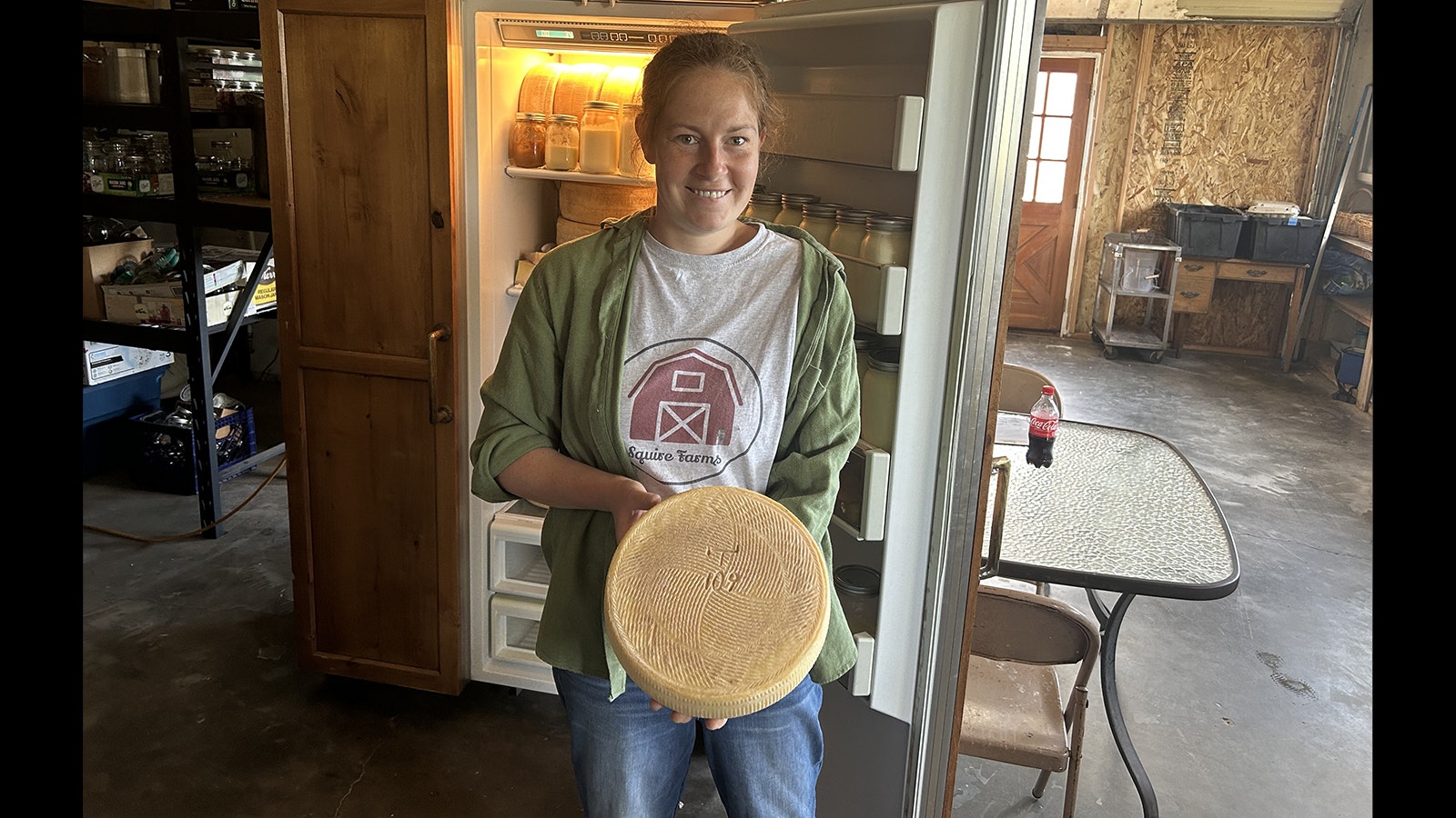 Artisan cheesemaker Suzanne Mate Lecuyer shows a wheel of hard cheese.