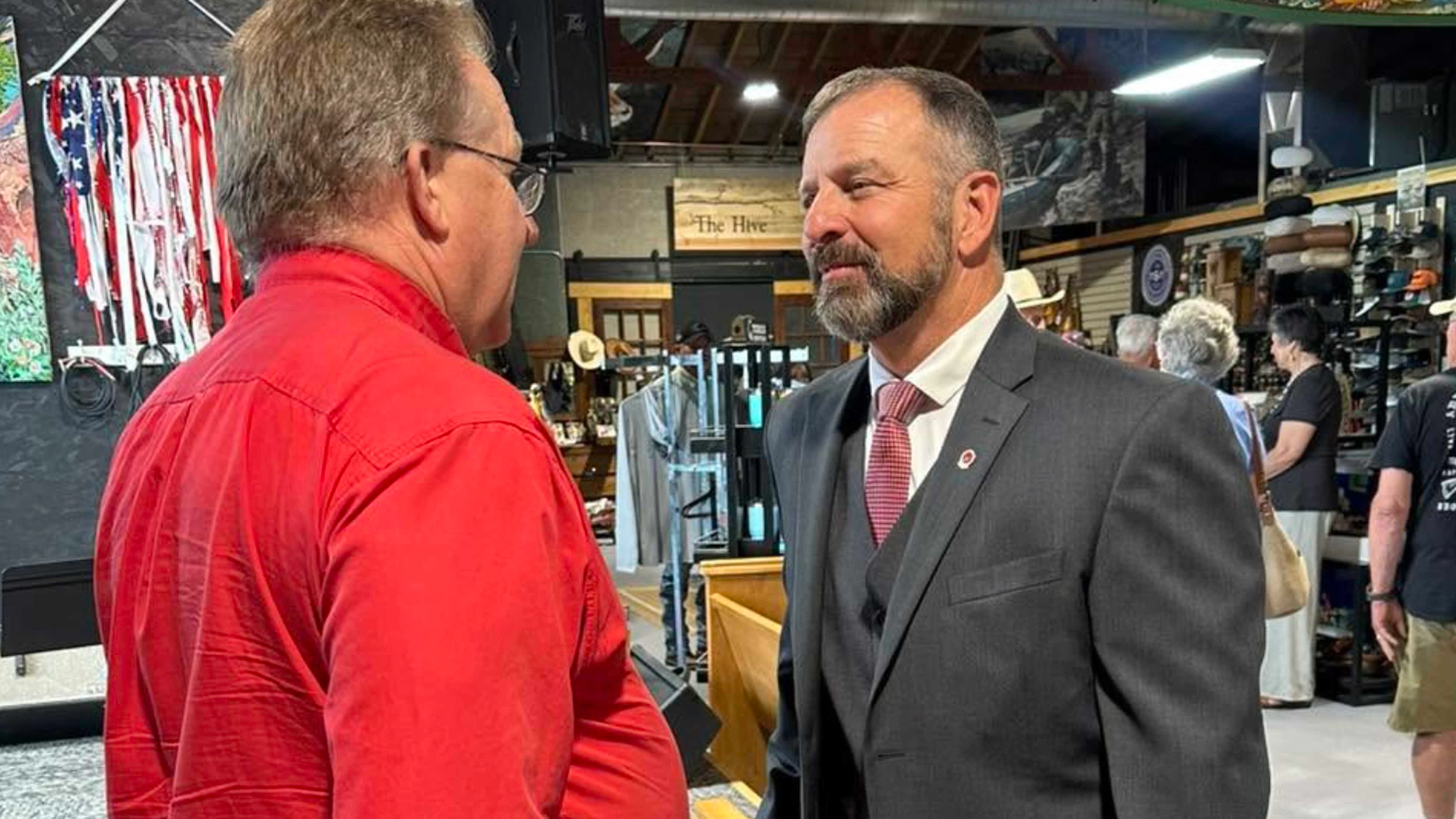 Eric Barlow (right) speaks to a voter days before the primary election.