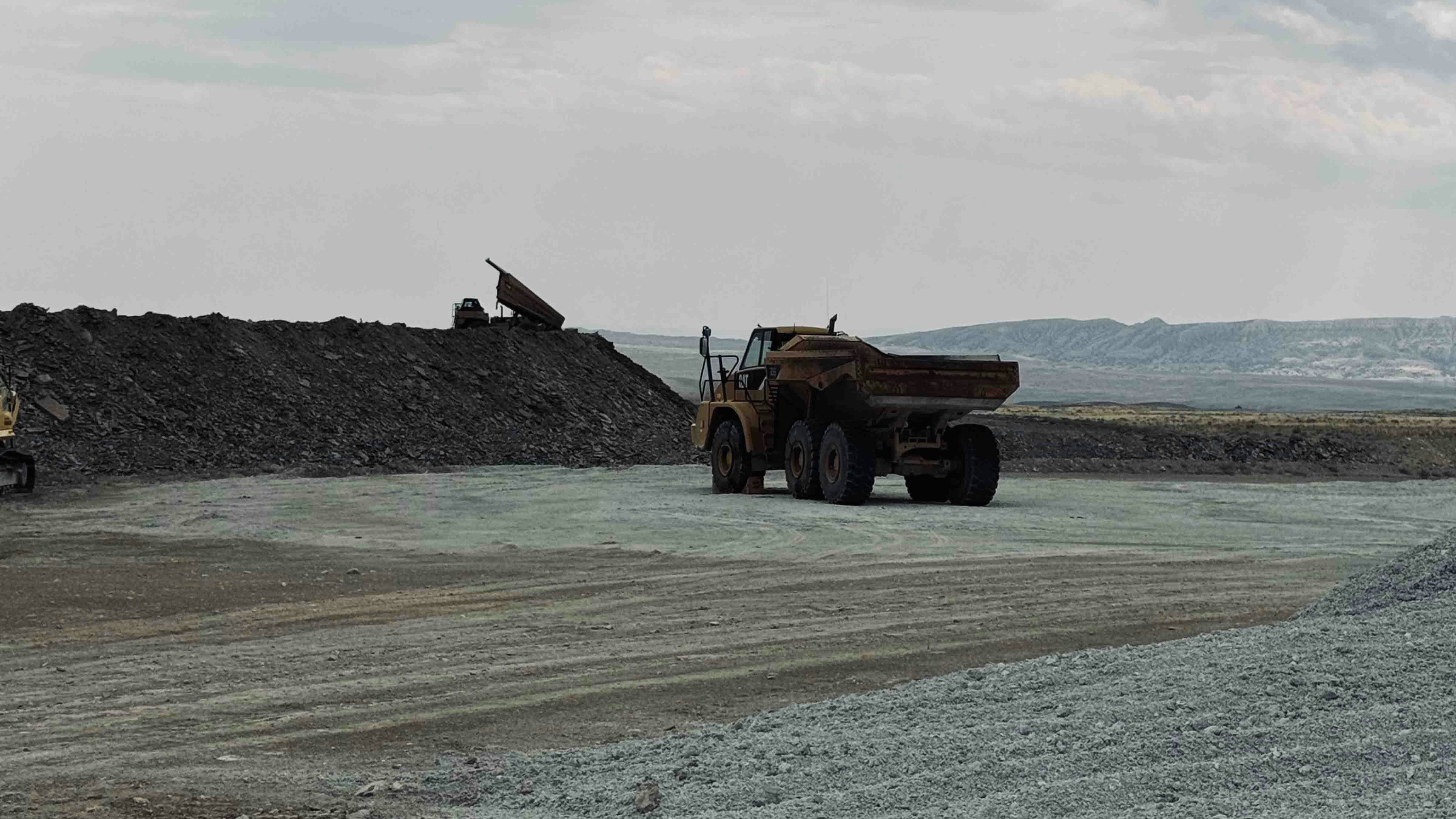 Above, a haul truck is removing overburden off one of the layers of bentonite in the Bighorn Basin.