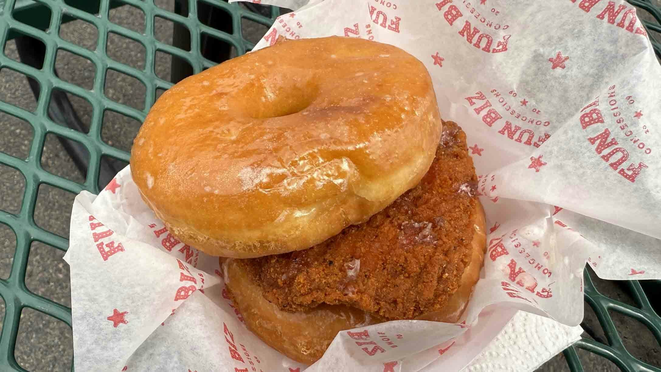 Nate Janousek, whose company Fun Biz is the exclusive concessionaire for Cheyenne Frontier Days, shows off his chicken sandwich with two glazed donuts acting as a bun.