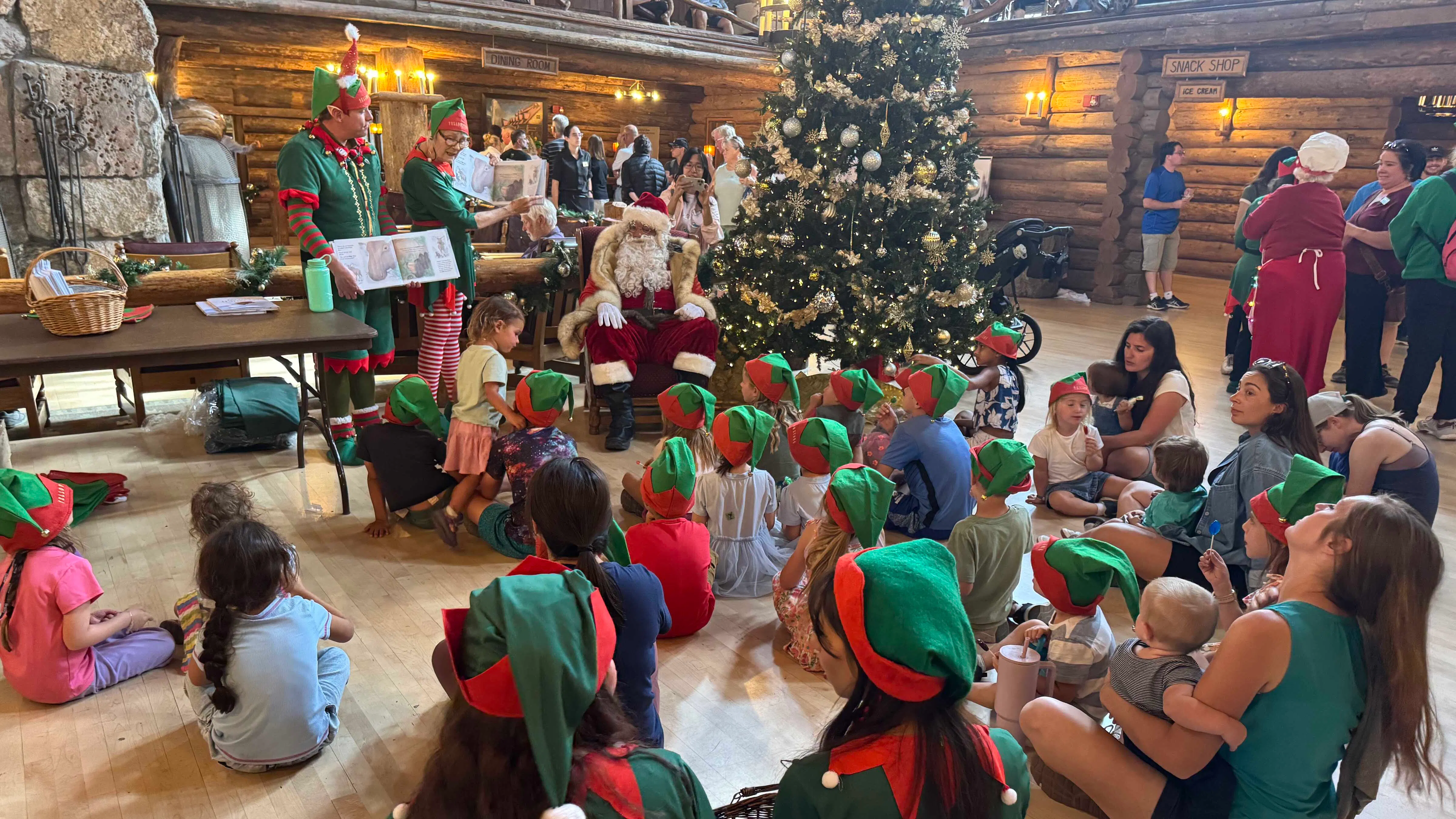 Santa Claus and his elves entertain tourists in the towering lobby of the Old Faithful Inn in an August tradition.