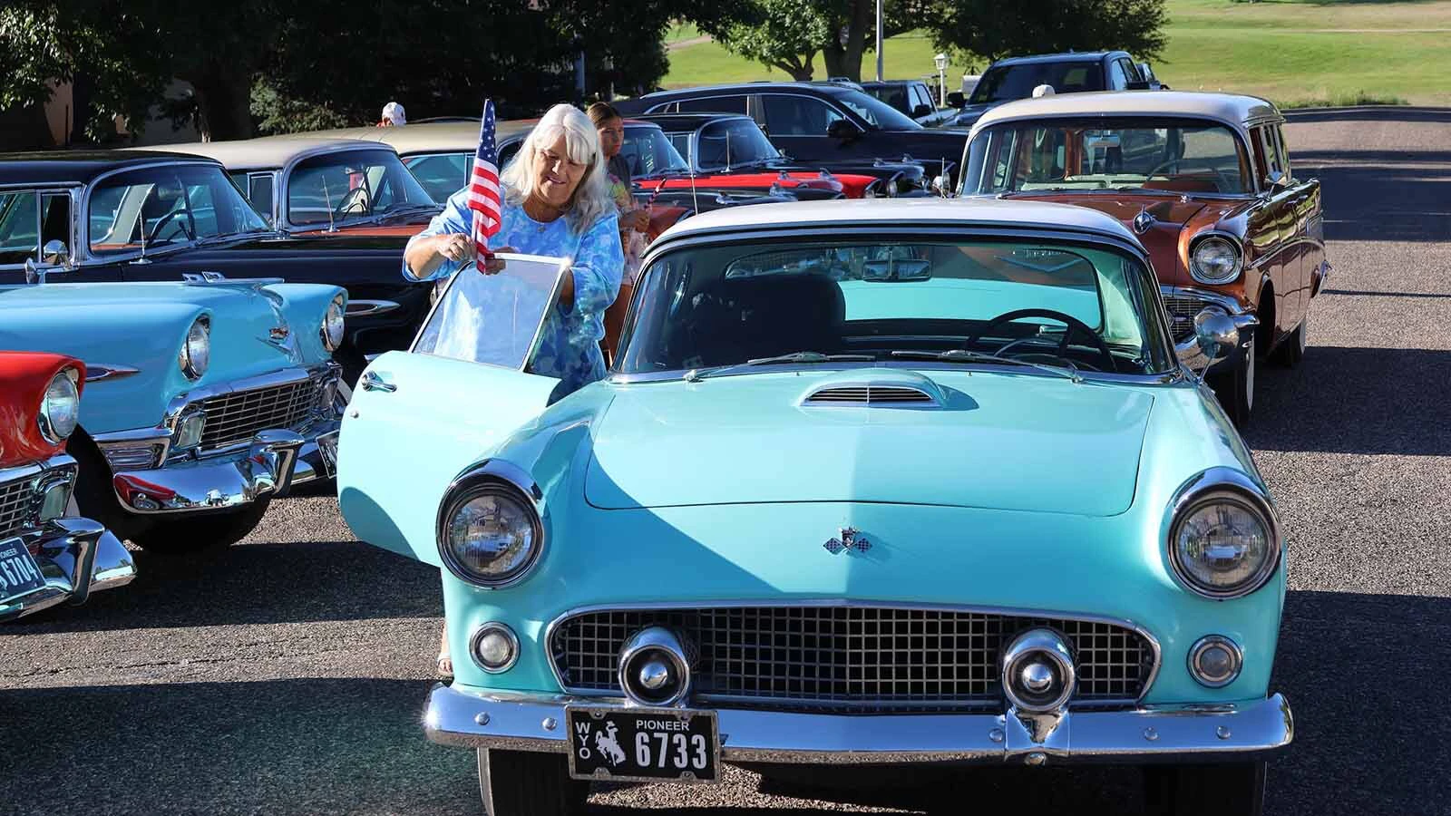 Kim Heston tries to put a flag on Frank Jones’ Ford Thunderbird. 