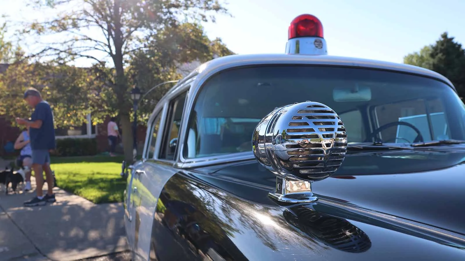  The siren for the 1955 Chevy police cruiser is classically mounted on the front left of the car. 