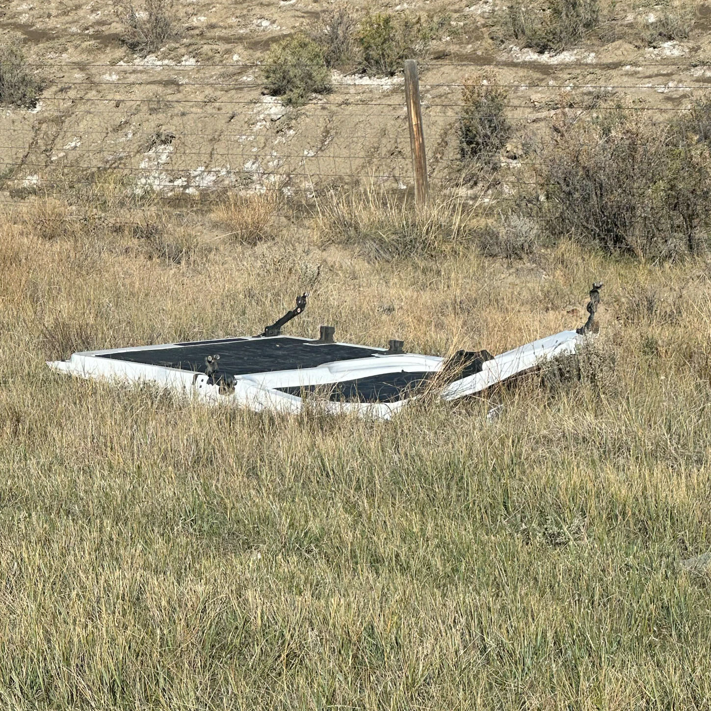 A door torn from the Bargreen Ellingson delivery van lies in the grass after the van rolled along Interstate 25 north of Casper on Friday.