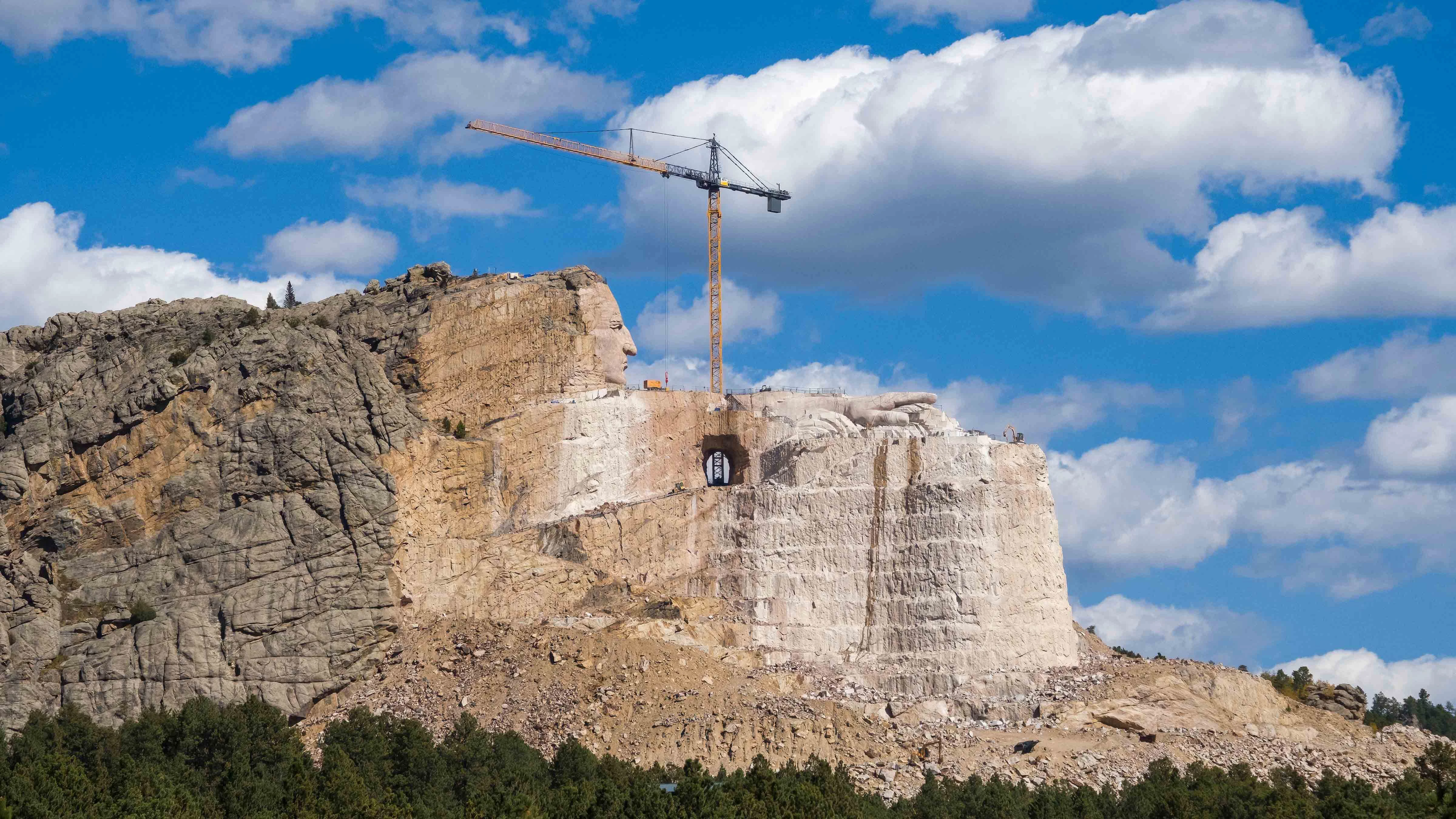 The face in the mountain is 87 feet tall.  The arm stretching across the granite is 243 feet long, ending in a nearly 30-foot-long pointing finger.  The horse’s head, still emerging from the mountain, will stand 219 feet high.