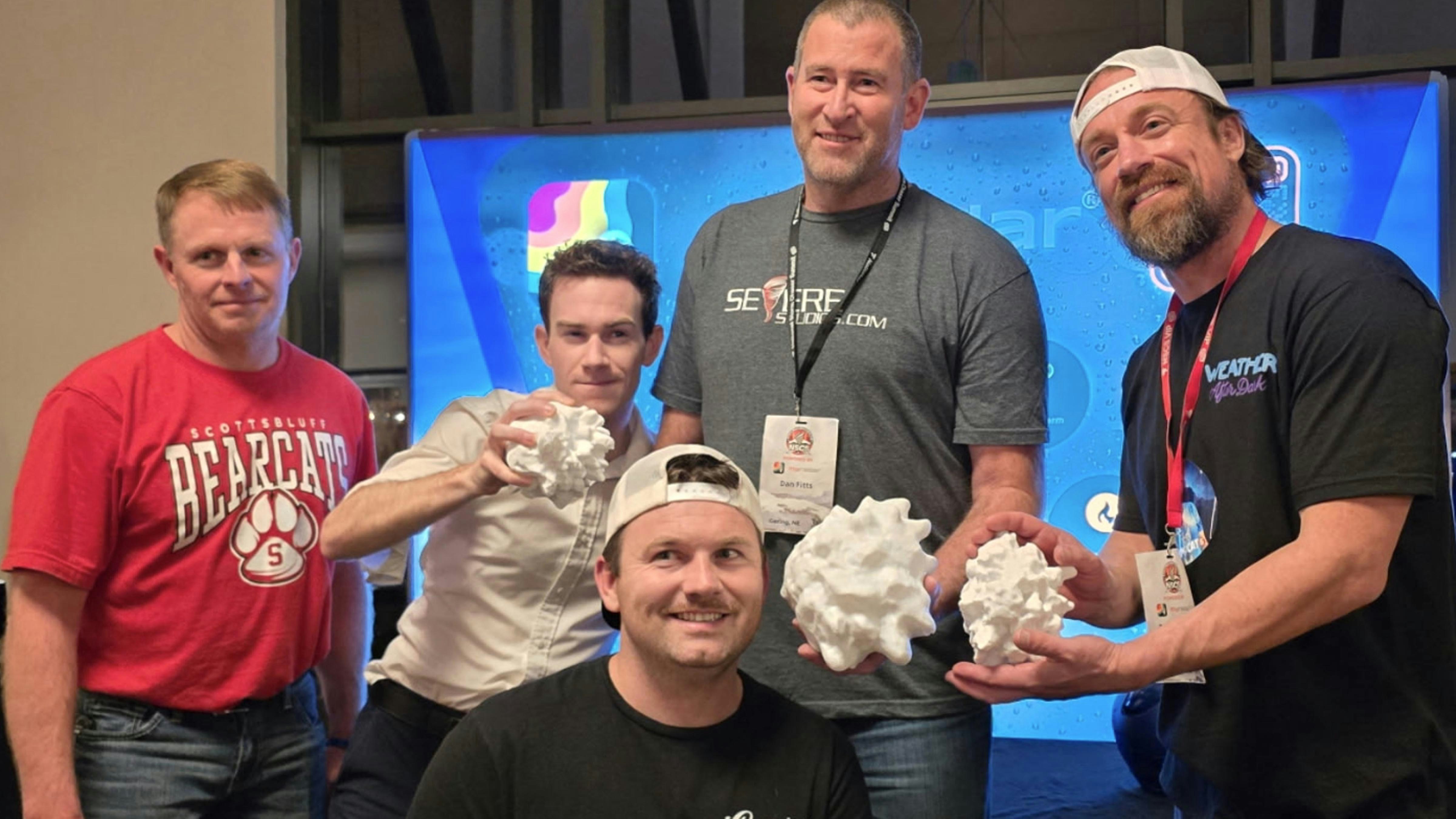 Storm chasers Jerry Doremus (left), Matthew Cappucci (white shirt), Dan Fitts (center) Jordan Hall (front) and Reed Timmer (right). They are all admiring several state record 3D printed hail stones. Fitts is holding the U.S. record from Vivian, South Dakota.
