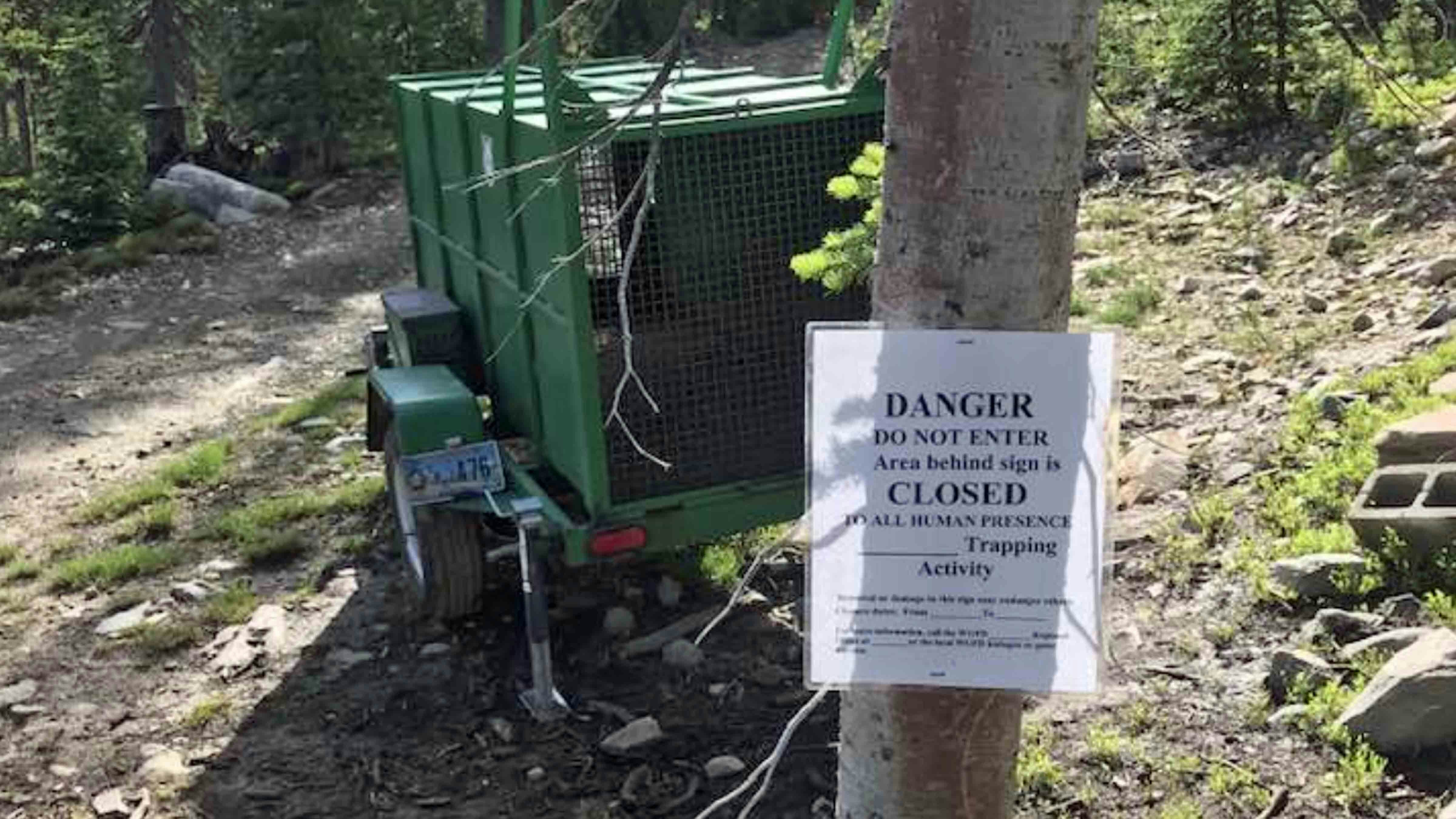 A bear trap and warning sign are posted in an area near private cabins in the Snowy Range in southern Wyoming.