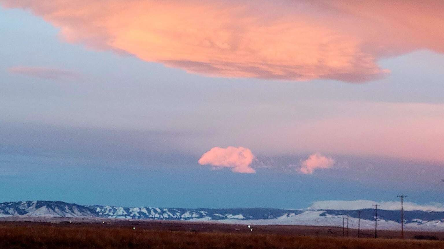 "Jan. 3 sunrise over the Snowies from the prairie east of Laramie. I love the layers of soft pastels, underlined by vivid blue sky and the recent snow on the mountains."