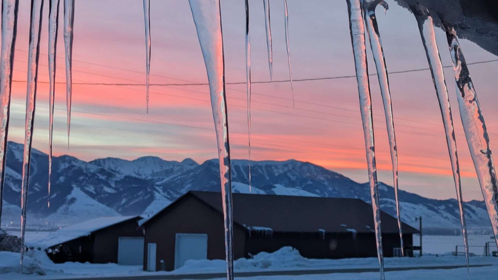 "Hey, it's warming up! Only -21 degrees this morning after an overnight low of -33. Sunrise through the icicles taken January 21 in Afton, WY."