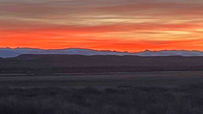 "Sunset over the Wind River Mountains from west of Riverton. The stunning orange highlights the peaks of the skyline."