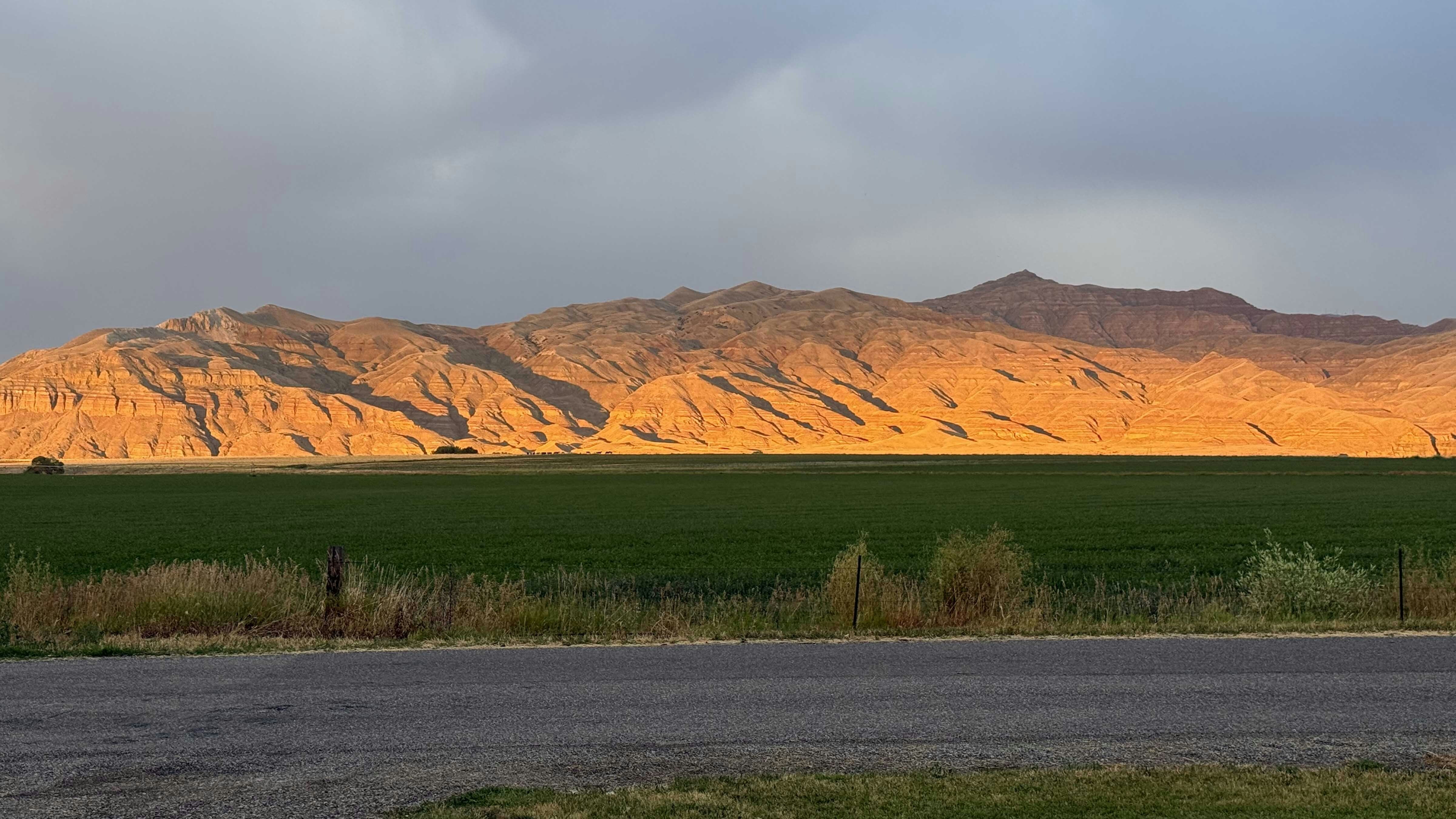 Beautiful sunset, with only the lower half of McCullough Peaks lit up and the dark sky in the background. Taken just west of Highway 14A, northeast of Cody.