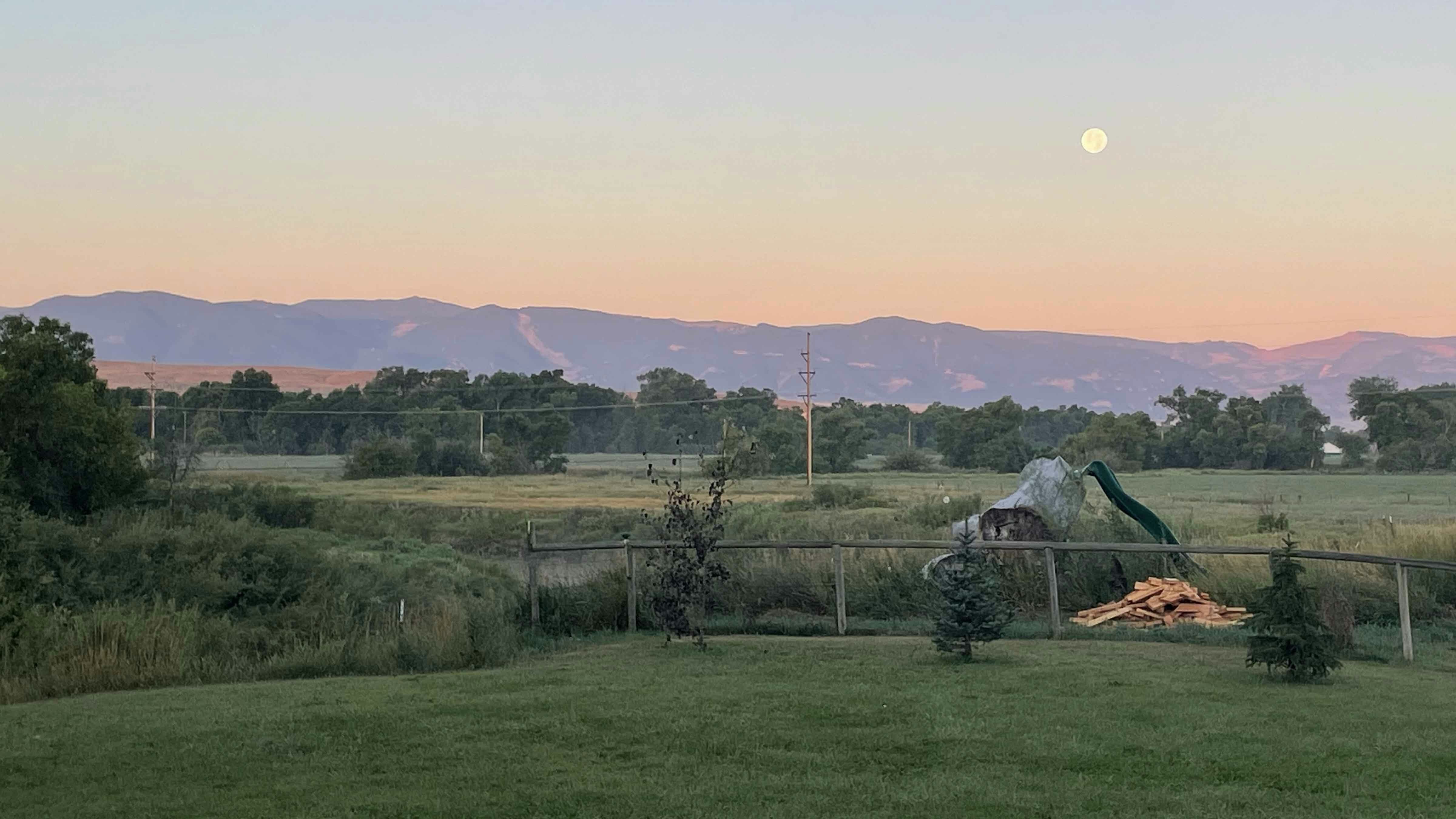 "Moonset at sunrise 6:24 AM on Tuesday facing the Big Horn Mountains across the Tongue River near Ranchester."