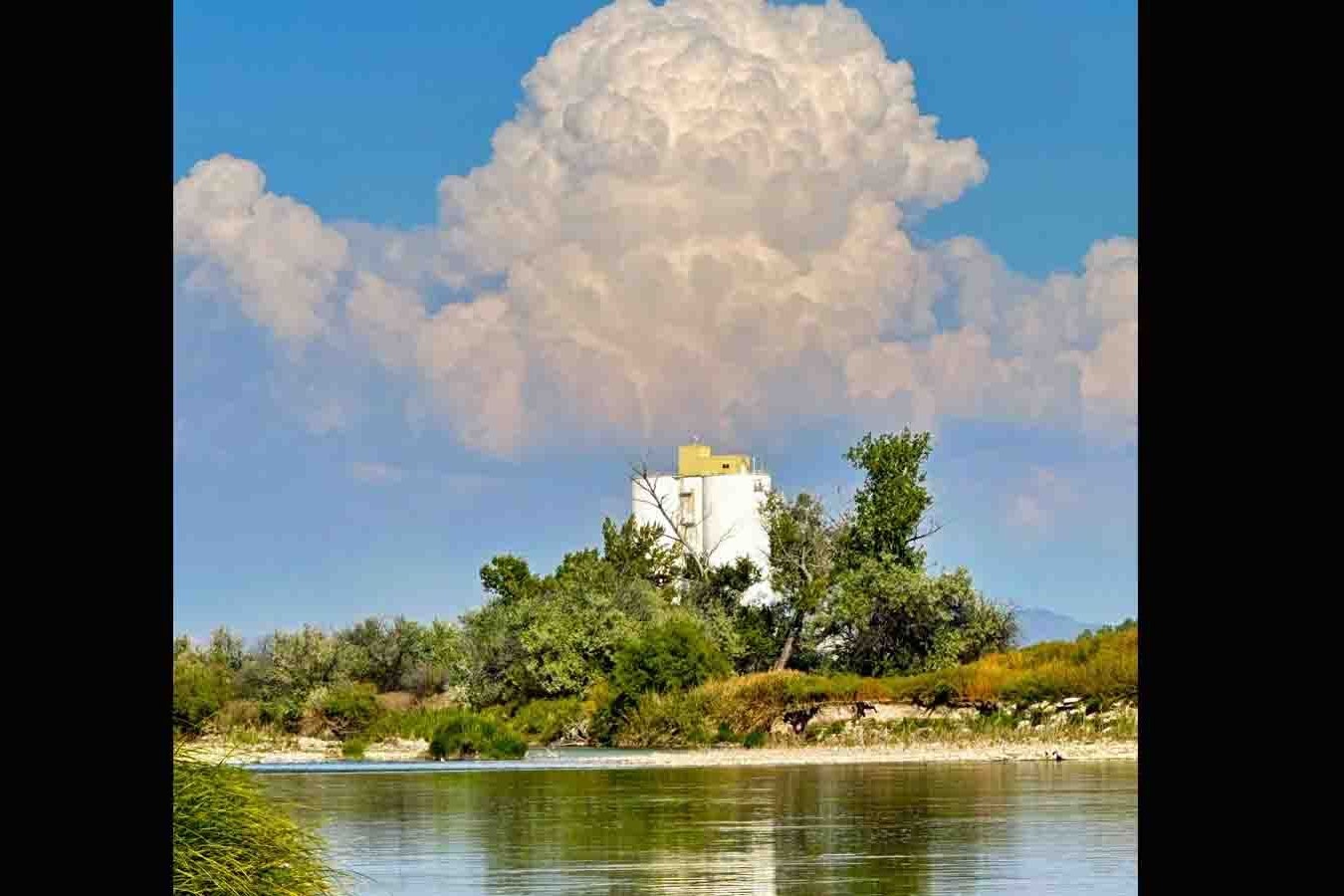 Cumulus clouds building with Worland sugar factory silo in foreground on Sept 21, 2023