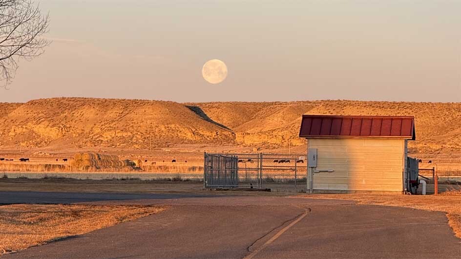 "Moon setting behind a hill taken at the Wyoming Boys School in Worland, Wyoming."