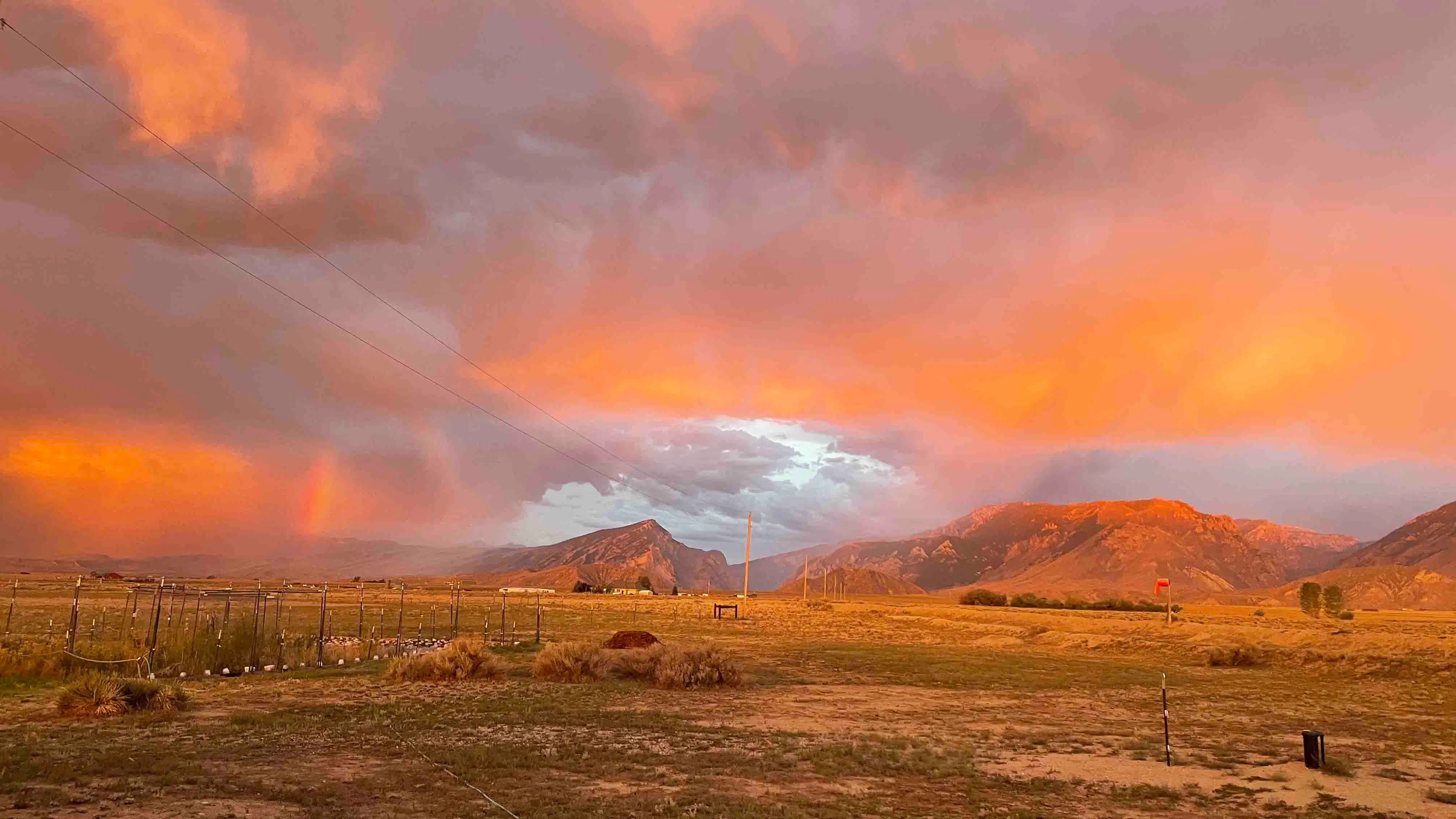 The light of sunrise is glorious on the clouds and mountains and there’s even a small bit of rainbow!