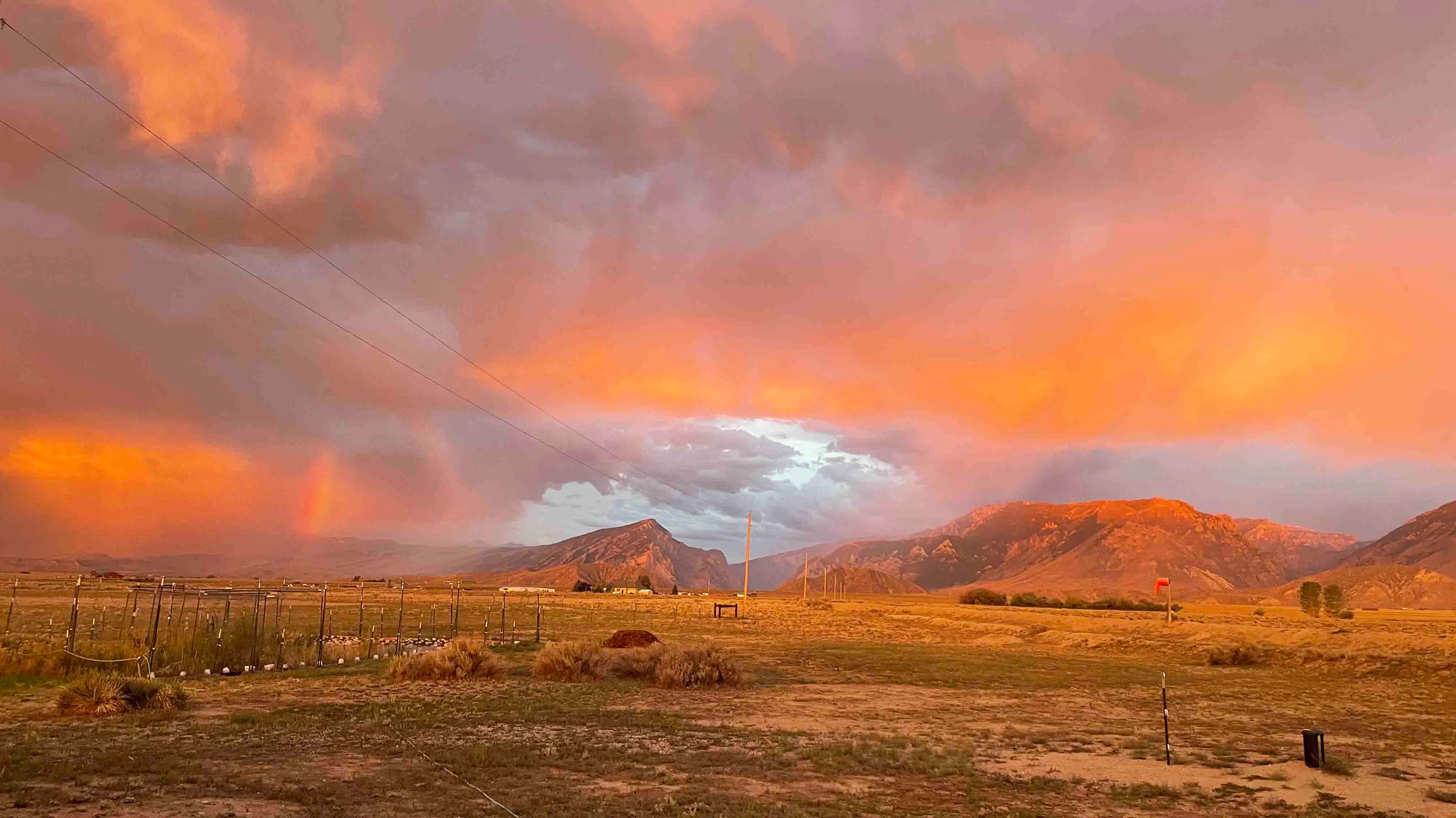 The light of sunrise is glorious on the clouds and mountains and there’s even a small bit of rainbow!