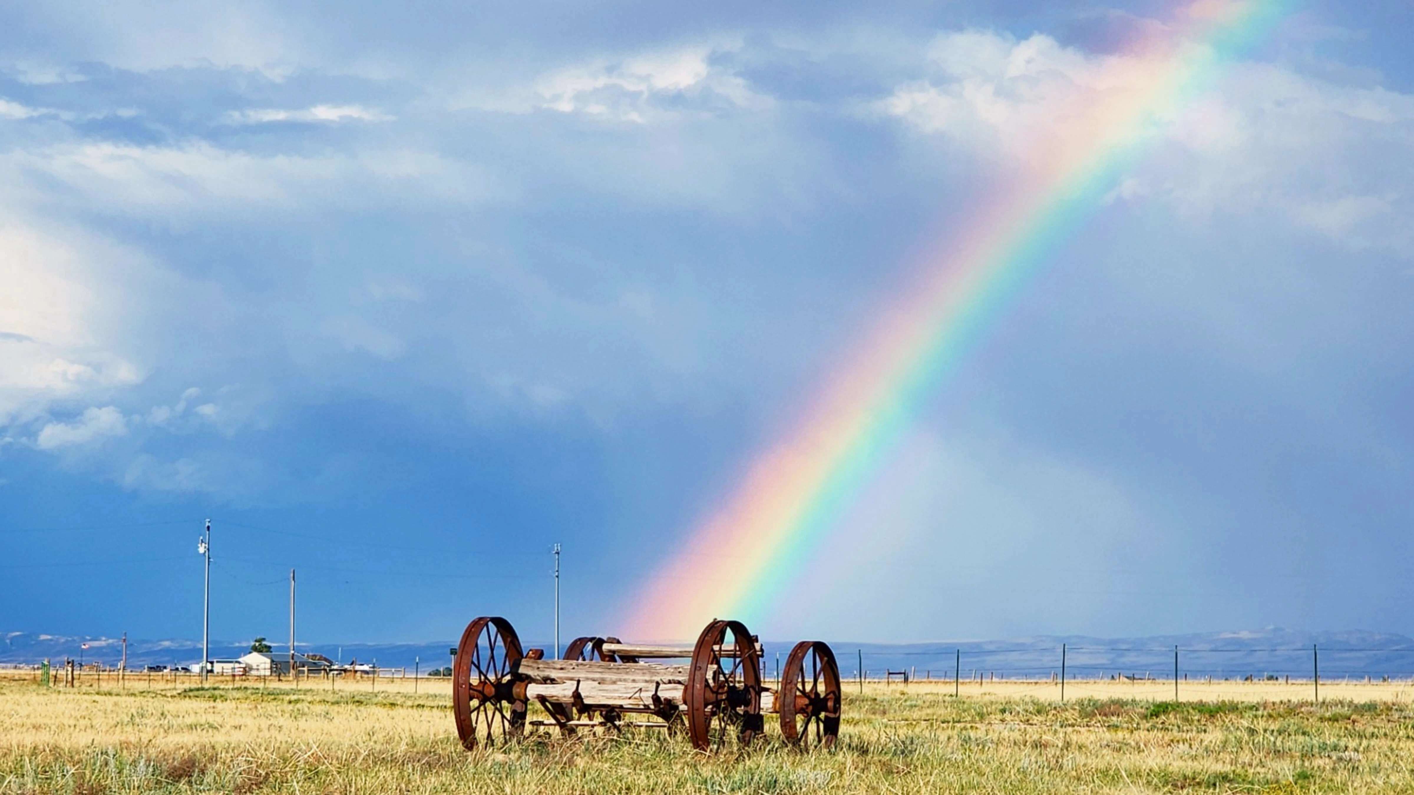 Rainbows and wagon wheels near Harmony, Wyoming.