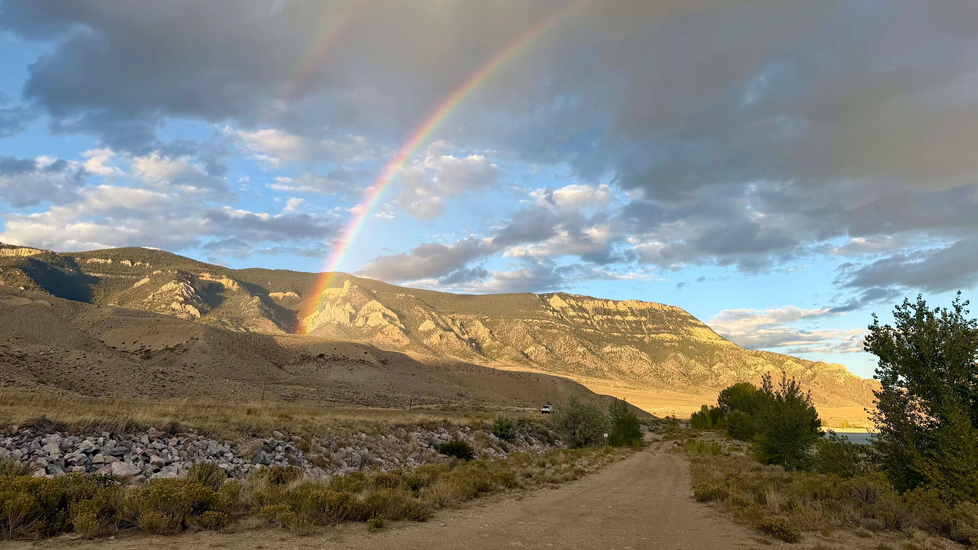 Evening shower with partial double rainbow on Rattlesnake Mountain next to Buffalo Bill Reservoir, Cody, WY.
