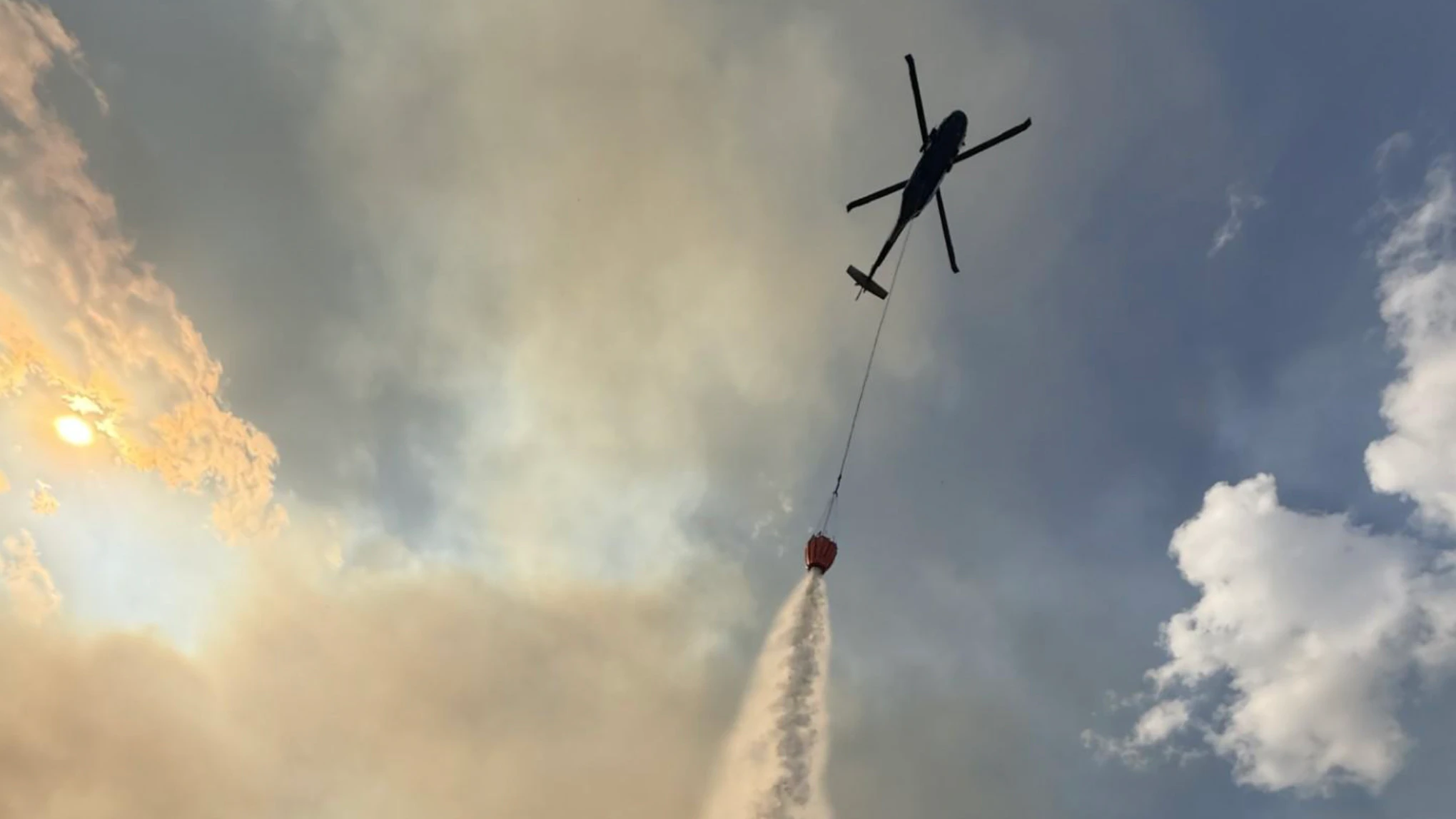 A helicopter performs a strategic water drop on the Weiser Knoll Fire