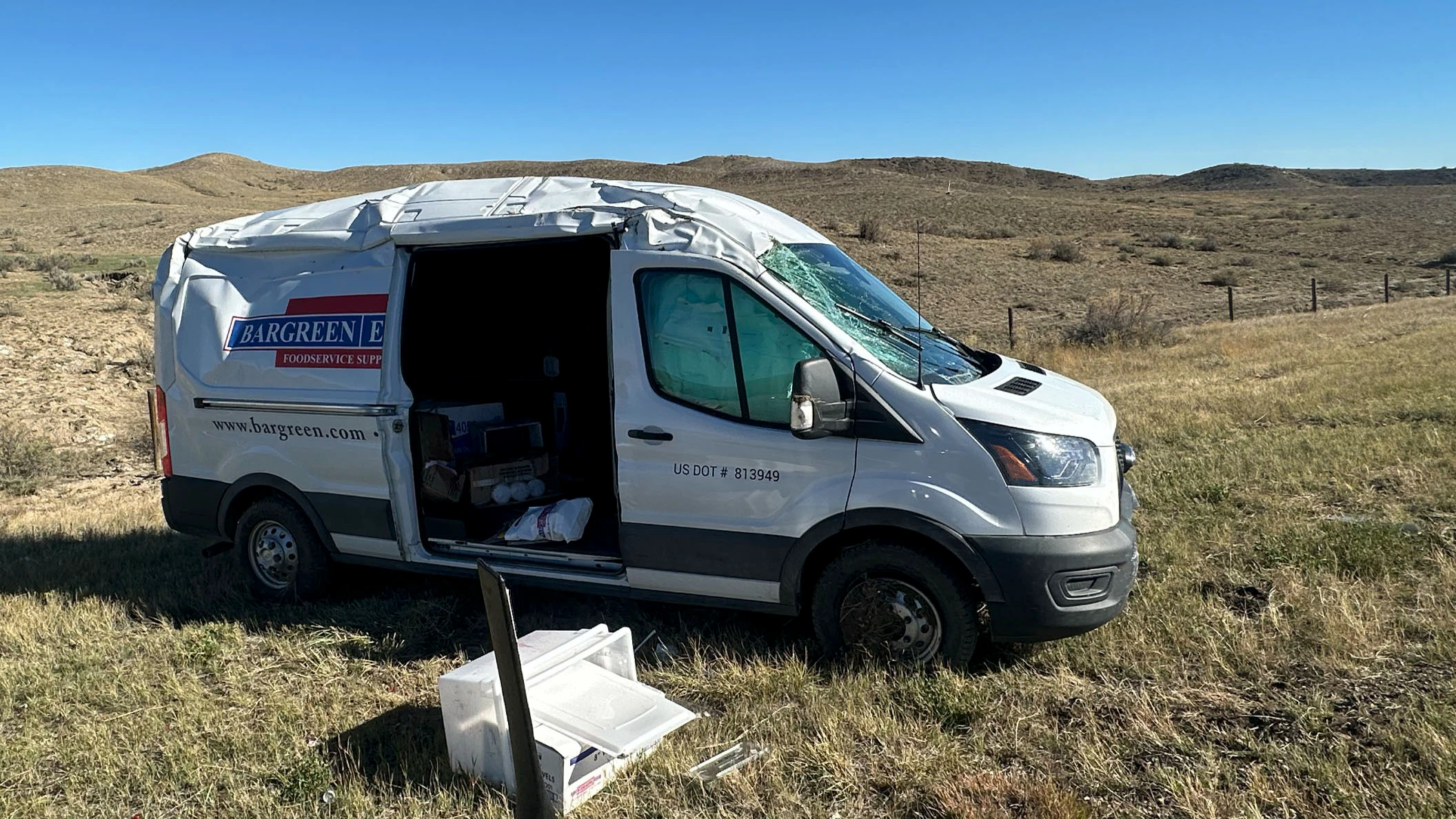 The Bargreen Ellingson delivery van sits heavily damaged after rolling along Interstate 25 north of Casper on Friday.