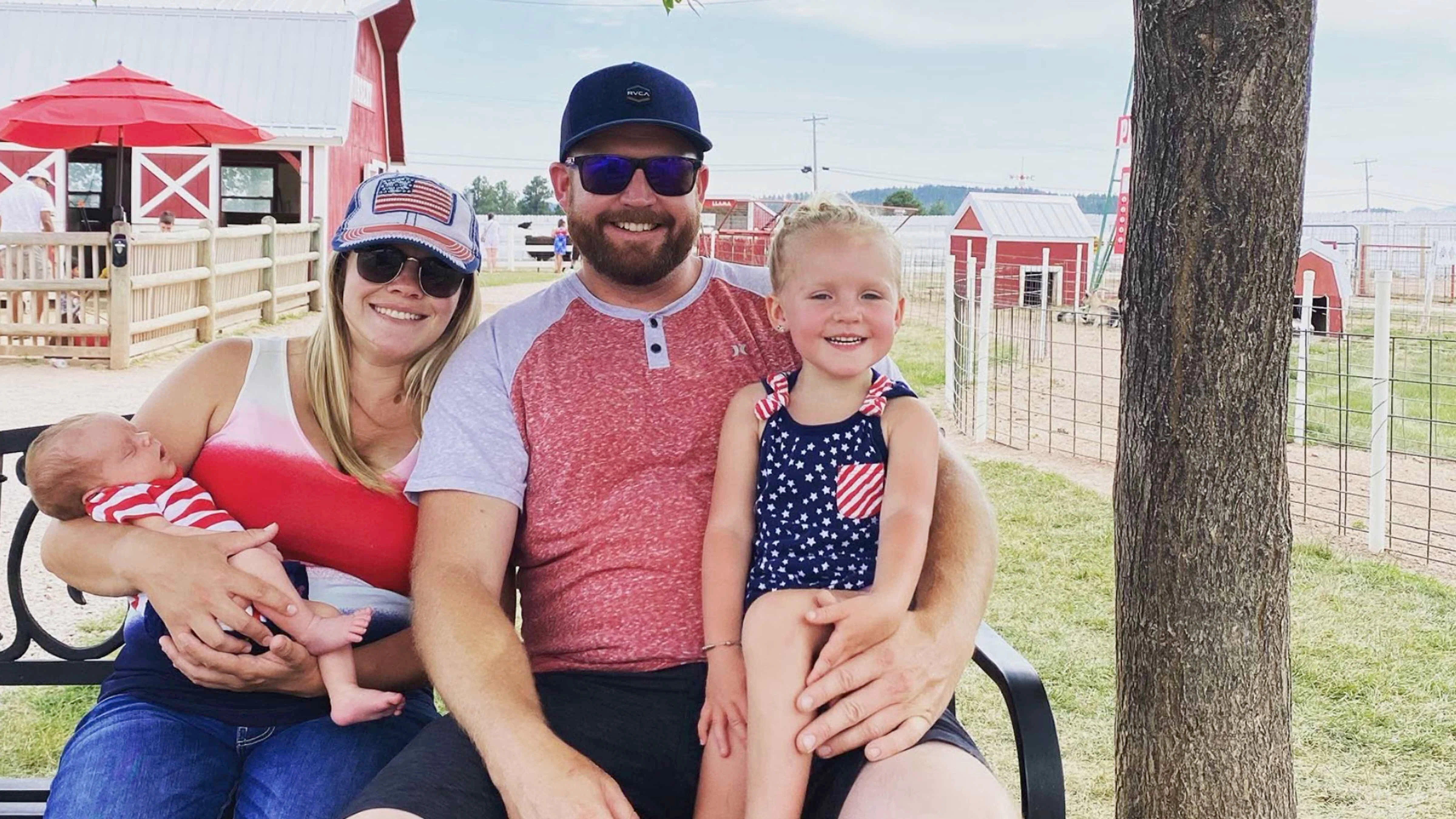 Ashley and Ian Monroe sit with their children in a family photo.